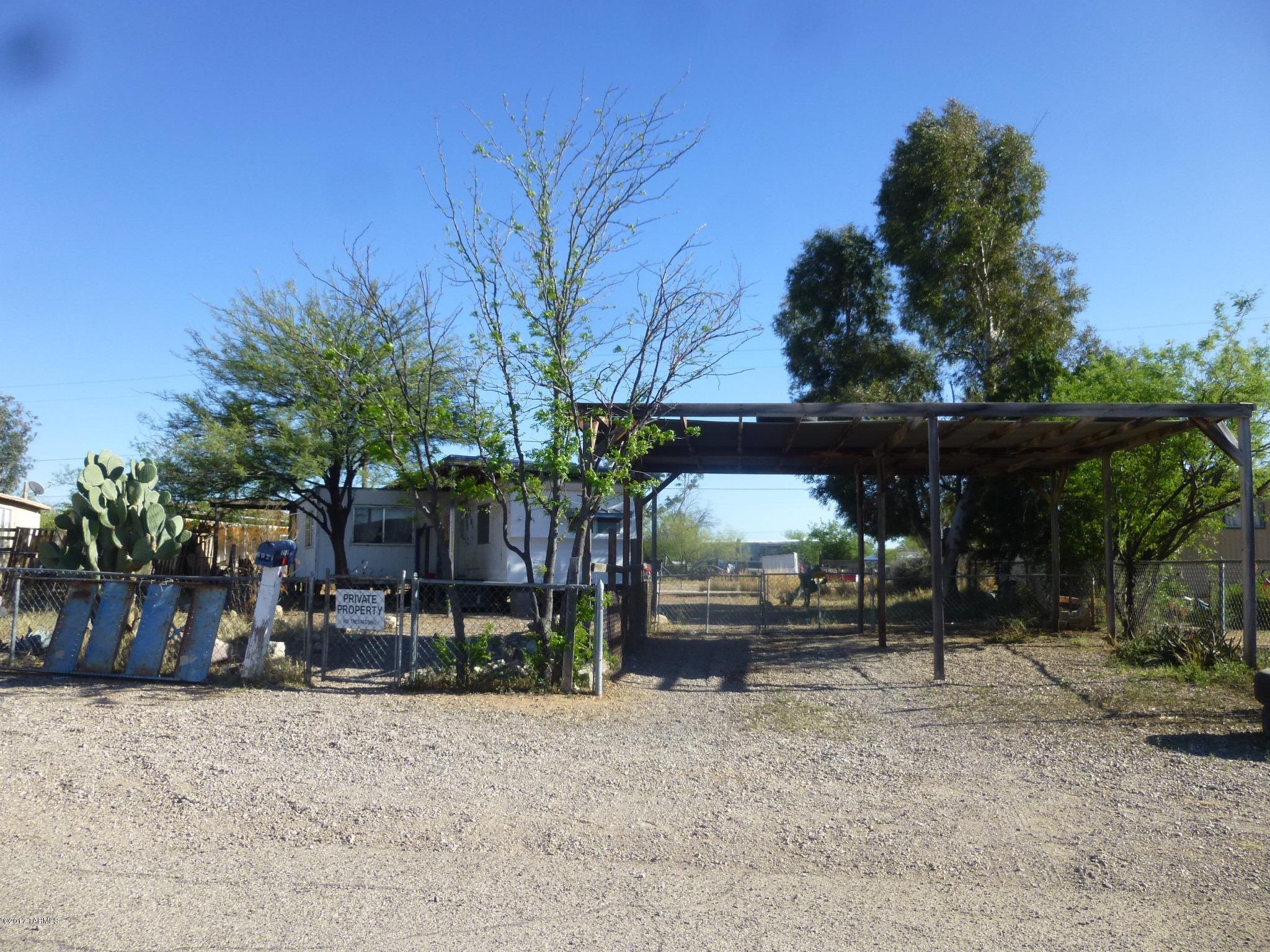 Affordable fenced lot with 2 carports on Tucson's growing southwest side is served by city water & sewer, TEP, & SWG. Paved road too. Sold AS-IS. Neighborhood is mostly manufactured homes, & includes community park. Existing abandoned 1958 Crestline mobile on lot is a major fix-up, not affixed, & not in seller's name. Bonded title would be required, or remove and replace. Seller might carry with minimum of $2500 down. Area is in floodplain, and in vicinity of Ryan Field airport.