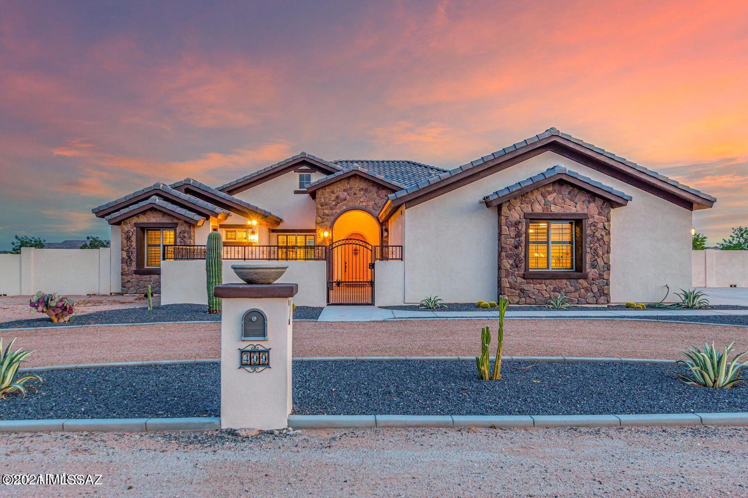 A rare find & the epitome of luxury horse property! Custom built FCP Barn w/ 2-12x12 stalls & 2-12x16 w/ mats, breezeways, 3 turnouts w GRINDINGS for dust-proof footing, insulated roof, tack, grain & hay rooms. Large wash area w/ mats, concrete floor w/ compacted granite, custom lighting w/ stall timers, industrial fans & misters. Also 30amp RV hookup & newly built modular workshop w/ A/C. The yard has custom built snake resistant fence & block wall perimeter fencing.The beautiful kitchen offers two islands, upgraded shaker cabinets, S/S appliances, quartz counters & an apron sink. Paradigm water & scratch resistant flooring, plantation shutters stained to match the floor, bay windows & an inviting great room w/ state-of-the-art electric fireplace. Guest bedrooms feature ensuites & walk-in closets. The front guest room has a private entrance. The home also has spray foam insulation in the walls and ceiling for energy efficiency and a completely covered outdoor living area with tv and internet hookups. Other features include Pella windows and doors, quartz counters throughout, knotty alder door, 10 foot ceilings, water softener, RO system, wired for internet and cable, wired cameras, and dual zone HVAC and hot water. For a list of more features and upgrades click the docs tab.