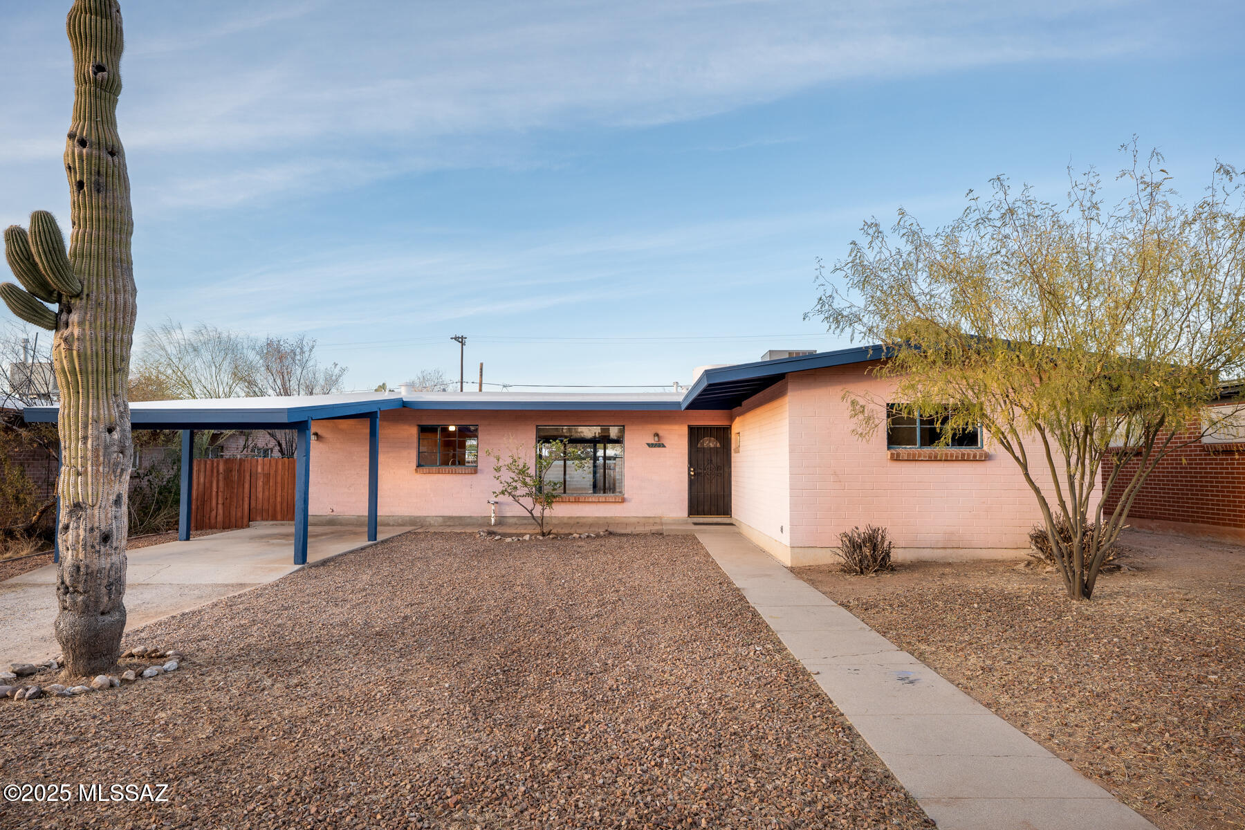 Mid-Century Mitman Maverick in Central Tucson - w/NEW ROOF. NEW CARPETING installed on April 18! This classic Tucson Ranch, built in 1959, features a unique transverse orientation (''T-shaped'') floor plan - horizontal large open living area with east-facing bedrooms perpendicular to the home! This 4-bed/2-bath mid-century home has exposed beams, high ceilings, and a large great room with mountain facing ''wall of windows!'' Roof replaced December 2024, with freshly painted eaves/trim, and exterior tool/storage shed, as well as new dual-flush toilets in both bathrooms! The large floor plan boasts nearly 1,700 square feet of living space, Super Saltillo Mexican tile in dining/kitchen area, large storage closet, central cooling, forced air gas heat, with a walk-in pantry in the kitchen! Step outside to the large front yard and backyard, with desert flora, flower beds, plenty of parking, and an attached one-car carport, depictive of mid-century styling! Welcome to YOUR Mid-Century Mitman Home! See YOUR Mid-Century Mitman Home Features, Improvements List, and Floor Plan! UPDATE: New Carpeting installed on April 18!