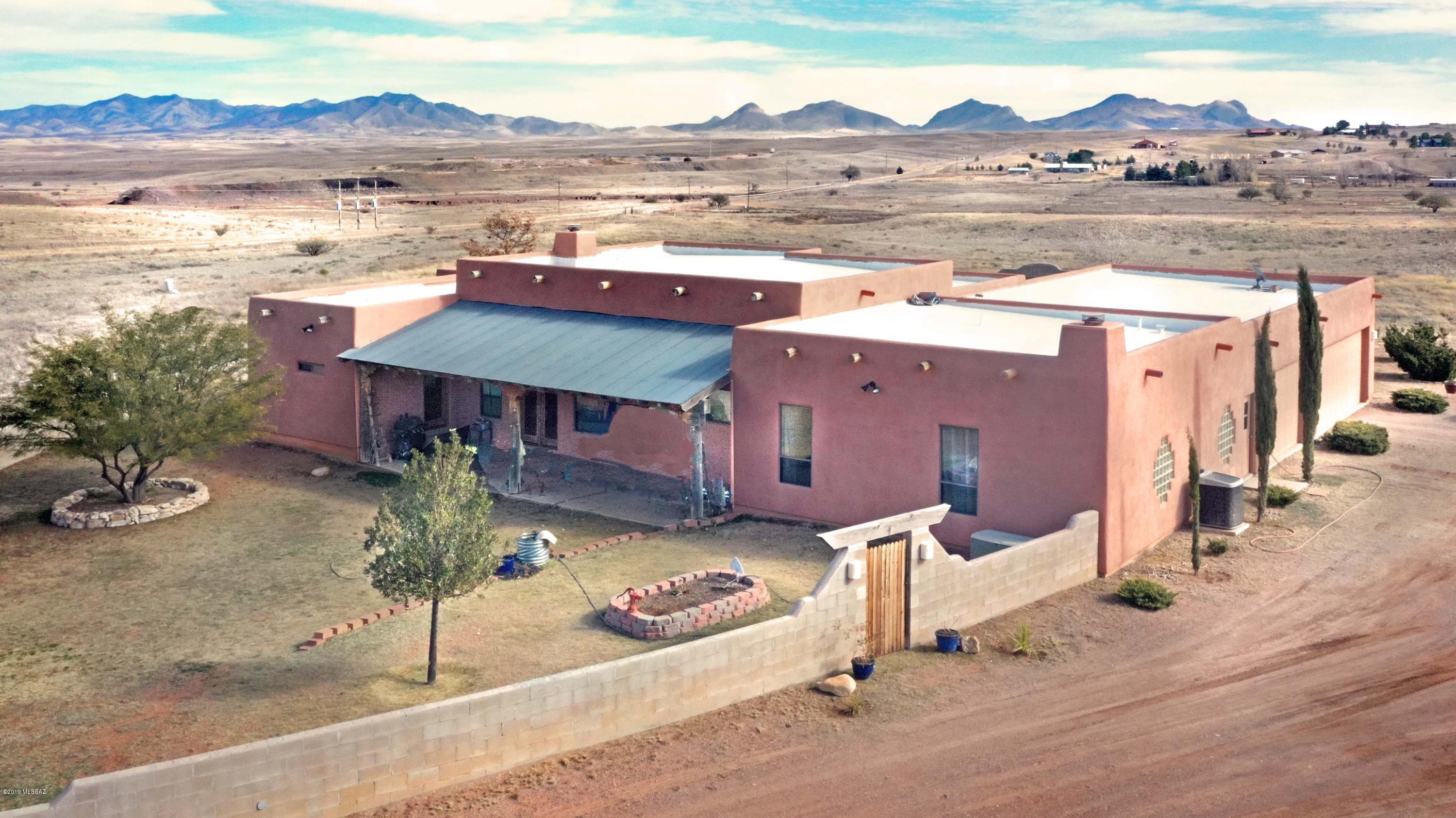 Immediately obvious when visiting this handsome Mountain Empire home are its gracious proportions, well built quality & pride of ownership. A 3,018sf contemporary Santa Fe w/3Be/4Ba/Office-Be/3carG, there's plenty of room for everyone. On 21.37 acres overlooking the Mustang & Whetstone Mtns & ringed by many others, the views are stunning & there's VINEYARD POTENTIAL! No HOA so no restrictions apply, making it easily adaptable to your lifestyle & requirements. Soaring ceilings are richly accented by exposed Pine posts, beams & plank details. Easy-care tile floors in the common areas, carpet in the bedrooms; the home has dual/zoned heating-cooling,  ceiling fans & insulated Garage. The fully appointed Kitchen awaits your family & friends. Centrally located, a great home & tremendous value.