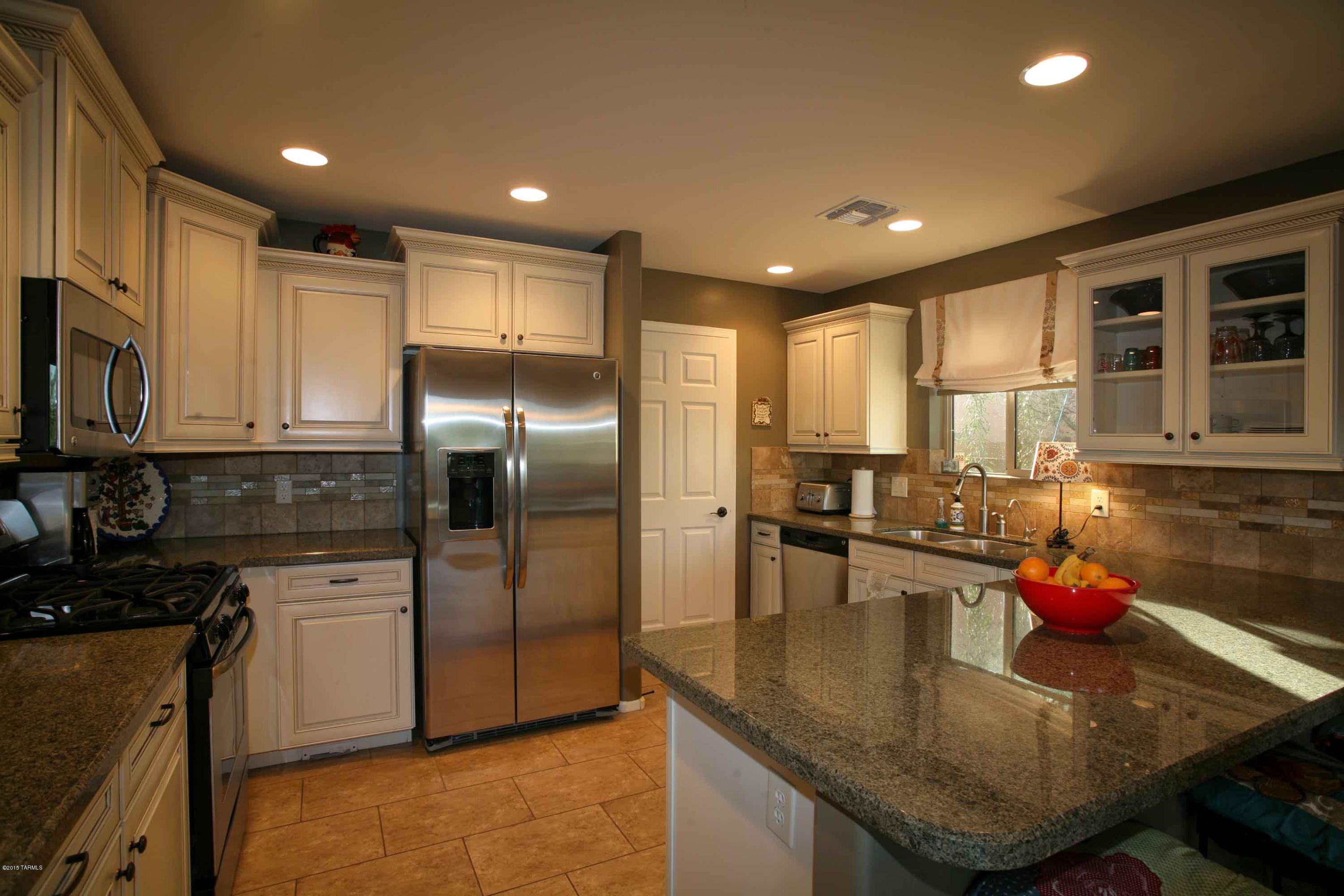 WOW!!! Such a superb lot seems like your own acreage! Fantastic Catalina Mountain views and green space on one side AND behind. Only ONE neighbor who is well blocked by lush foliage. A former MODEL HOME upgraded from top to bottom including beveled-edge granite counter, staggered kitchen cabinets w/molding, glass fronts, and pullouts, stainless steel appliances, epoxy coated garage floor, high end neutral carpeting, rectangular tiles, walkin pantry, custom paint & custom
designed wood shutters, solar power (owned not leased), central vacuum, tankless gas water heater (NEVER run out of hot water), fully landscaped front and rear yard w/beautiful mature trees. Upstairs family room w/full length patio facing east to admire the mountain views. PRIVATE! Low utility bills.