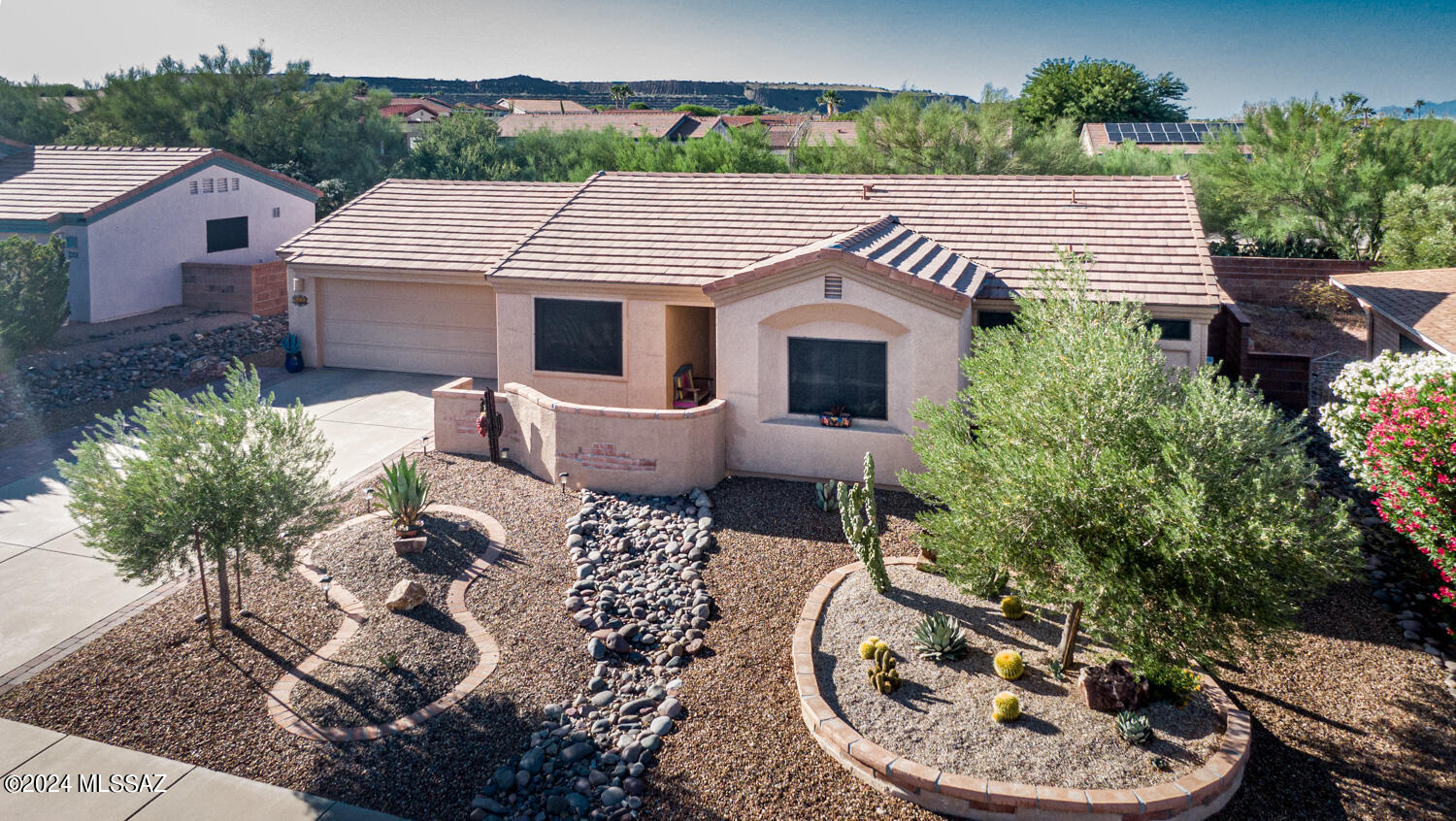A Charming Las Campanas Home, a Front Courtyard with views of the Santa Rita Mountains, 2 Bedrooms, 2 Baths, Living /Dining, Nook and an Oversized Garage with plenty of Storage & a Laundry Tub, Tile Floors throughout, Updated Kitchen, Under Cabinet Lighting, Ceiling Fans, Whole Home Water System. A very Private Rear Yard that backs up to Natural Common Area, Covered Patio, extra Pavers, Fruit Trees and its own Water Feature. Very Well Maintained, Nice and Clean, Must See!!!