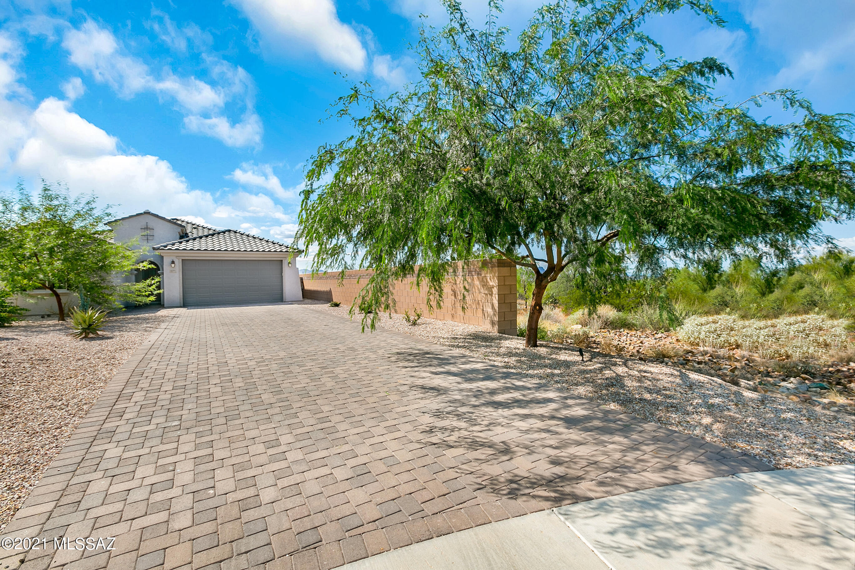 Beautiful Pulte home in coveted, gated Tangerine Ridge. Located at the end of a cul-de-sac, abutting acres of natural desert common area. Spectacular mountain and sunset views from inside and out. Upgraded kitchen boasts Quartz counter tops, glass mosaic tile backsplash, stainless steel appliances, six burner gas cooktop, 42'' upper cabinets and dove tailed/soft close drawers. Beautiful wood look porcelain tile throughout, except bedrooms. Full length sliding glass door from dining area provides natural light terrific views and access to the unbelievably awesome rear yard with fabulous pool and spa designed and constructed by renowned pool builder Cimarron Circle, plus turf area, travertine surrounds, patios and awesome fireplace . One of the largest lots in the neighborhood, with very long paver driveway. Separately fenced area in rear yard with fruit trees. Electric awning.