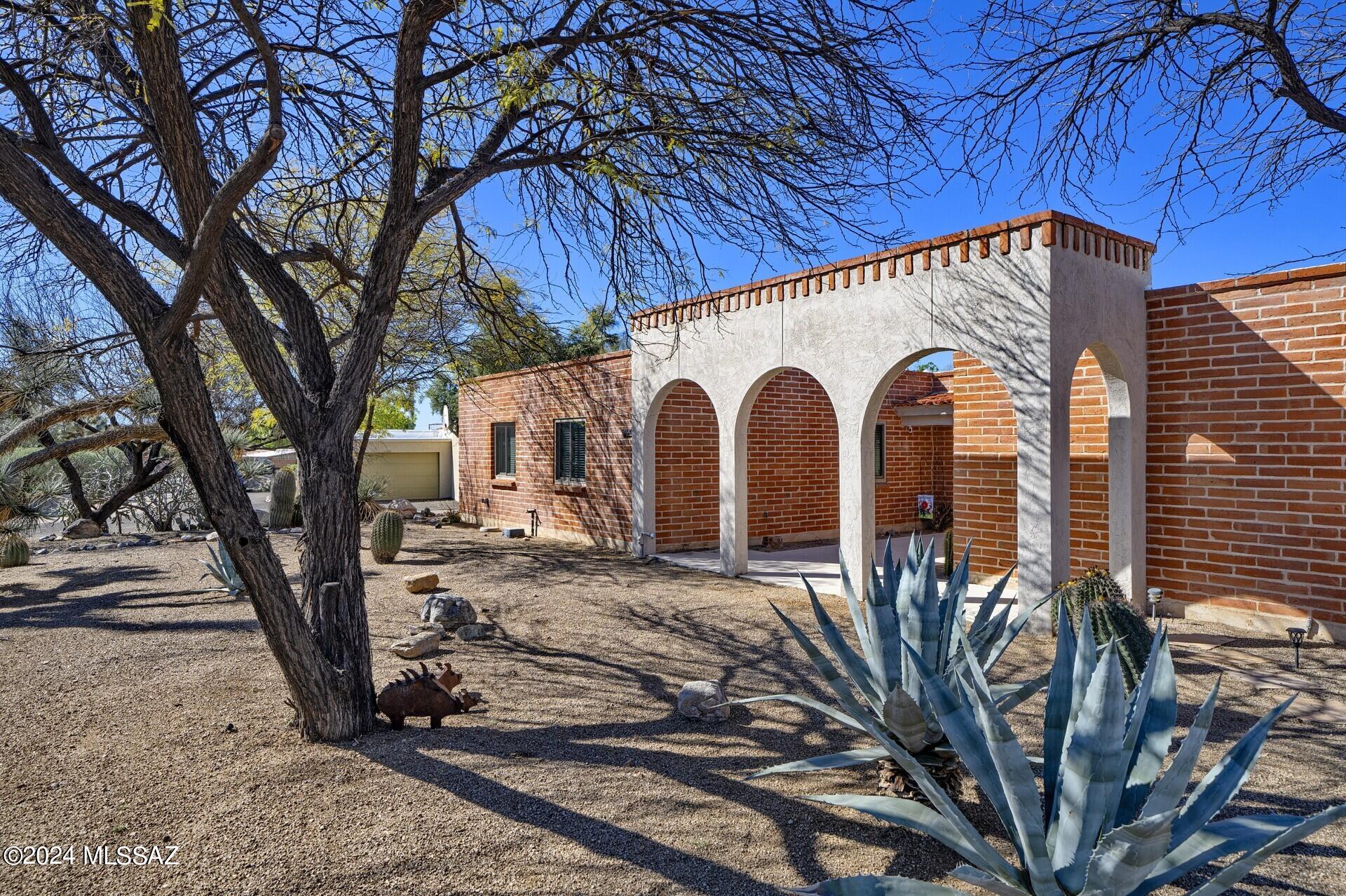 Beautiful 4 Bedroom/3 Bath Territorial with great curb appeal. Open floorplan. Spacious entry foyer w/arches opening to large Living Room w/lots of Natural Light. Dining area is perfect for entertaining family/friends; kitchen boasts beautiful custom cabinets, granite counters, large island + SS appliances. Generous family room, w/beautiful brick fireplace & a view of the mountains. Primary bedroom accommodates king-sized bed, offers lots of closet space & wood-look tile floors. 3 other bedrooms = room for family, guests or home office. Newer Anderson windows/doors throughout most of home. Great backyard offers a 37' pool (re-plastered in 2021), newly refinished ''flagstone'' look patio(2024), firepit, long covered porch. Convenient to Udall Park, Sabino Canyon, The Loop, restaurants.