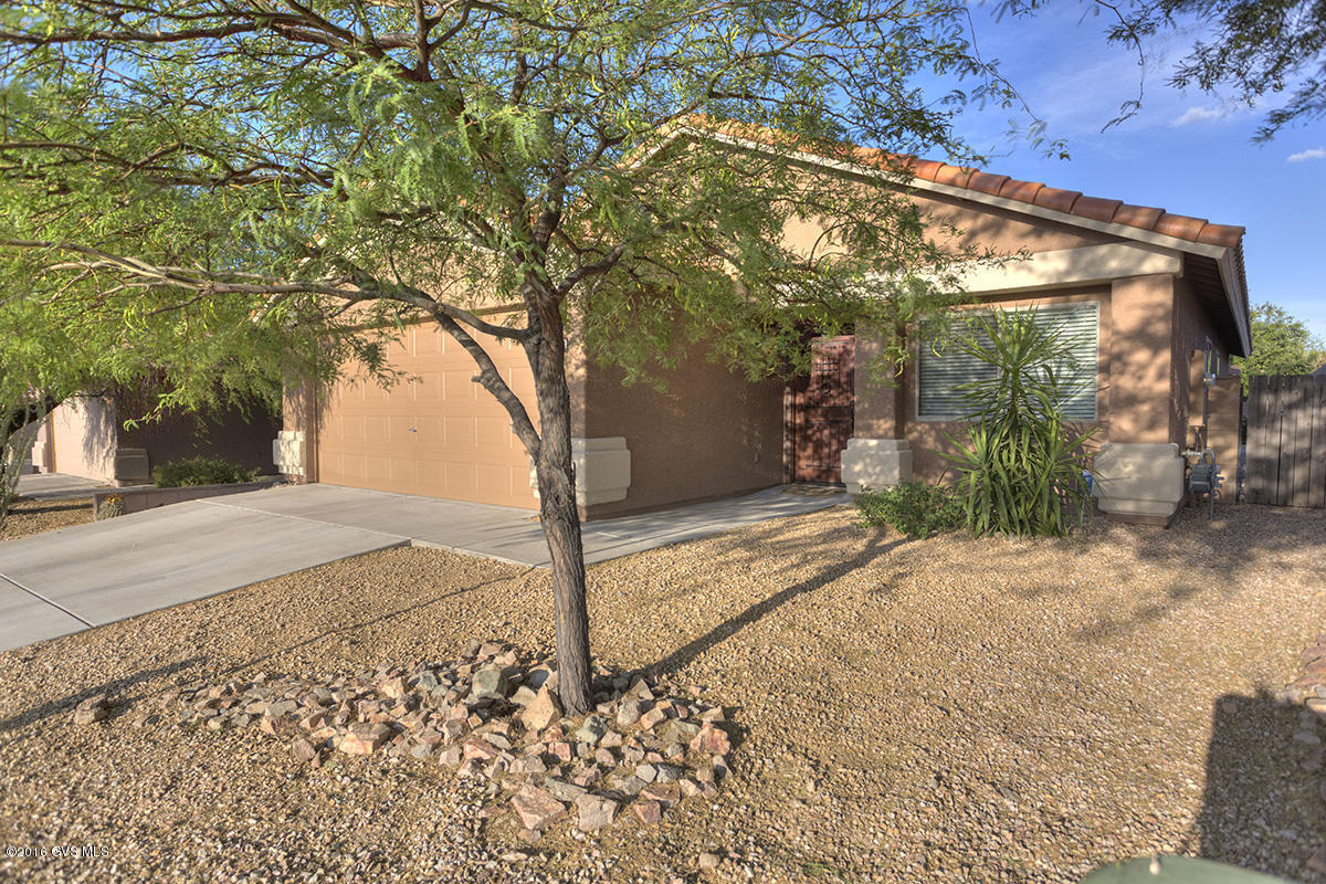 Beautiful move-in-ready home in the Santa Rita Ranch Community in Vail. CLEAN - CLEAN - CLEAN! Newer interior and exterior paint with a custom solid wood front door. Open floor plan. Kitchen has newer appliances with a convection oven, 42'' upper cabinets, some under cabinet lighting, lazy Susan, recessed lighting and a oversized pantry closet. Family room has a gas fireplace surrounded by slate stone. Beautiful wood laminate floors in all bedrooms and slate stone throughout the rest of the house. Ceiling fans throughout. Laundry room has storage cabinets, and front load HE washer and dryer. Backyard features a nice-sized screened in patio, low care landscaping and mature fruit trees. This should be a must see on your list!