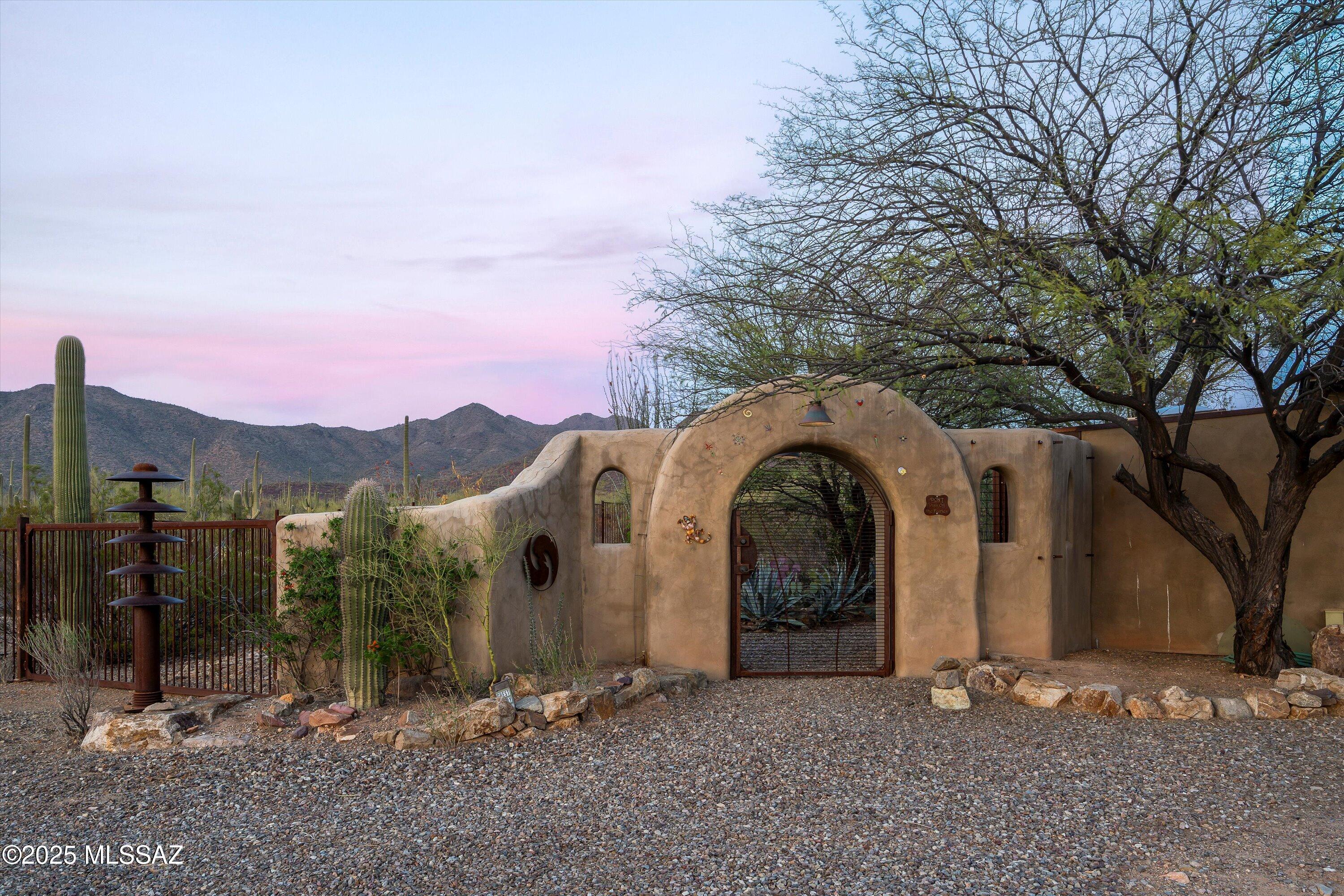 Magical one-of-a-kind custom rammed earth home on 5 acres surrounded by the breathtaking landscape of Saguaro National Park & Tucson Mountain Park. Enjoy modern comfort & rustic elegance w/reclaimed beam ceilings, stained concrete floors w/infloor radiant heat, metal roof & rusted metal details, multiple patios, a private well & optional shared well, plus a telescope observation deck w/electricity in a Bortle 4 Dark Sky designation for unmatched stargazing. Split floor plan includes serene primary suite w/rain shower, pebble floor, jetted tub & private screened porch on one side & guest suite w/kitchenette on the other, perfect for privacy & flexibility. Airbnb? This home is a RARE FIND for nature lovers, stargazers & those seeking luxurious, tranquil desert living. And, DoorDash delivers