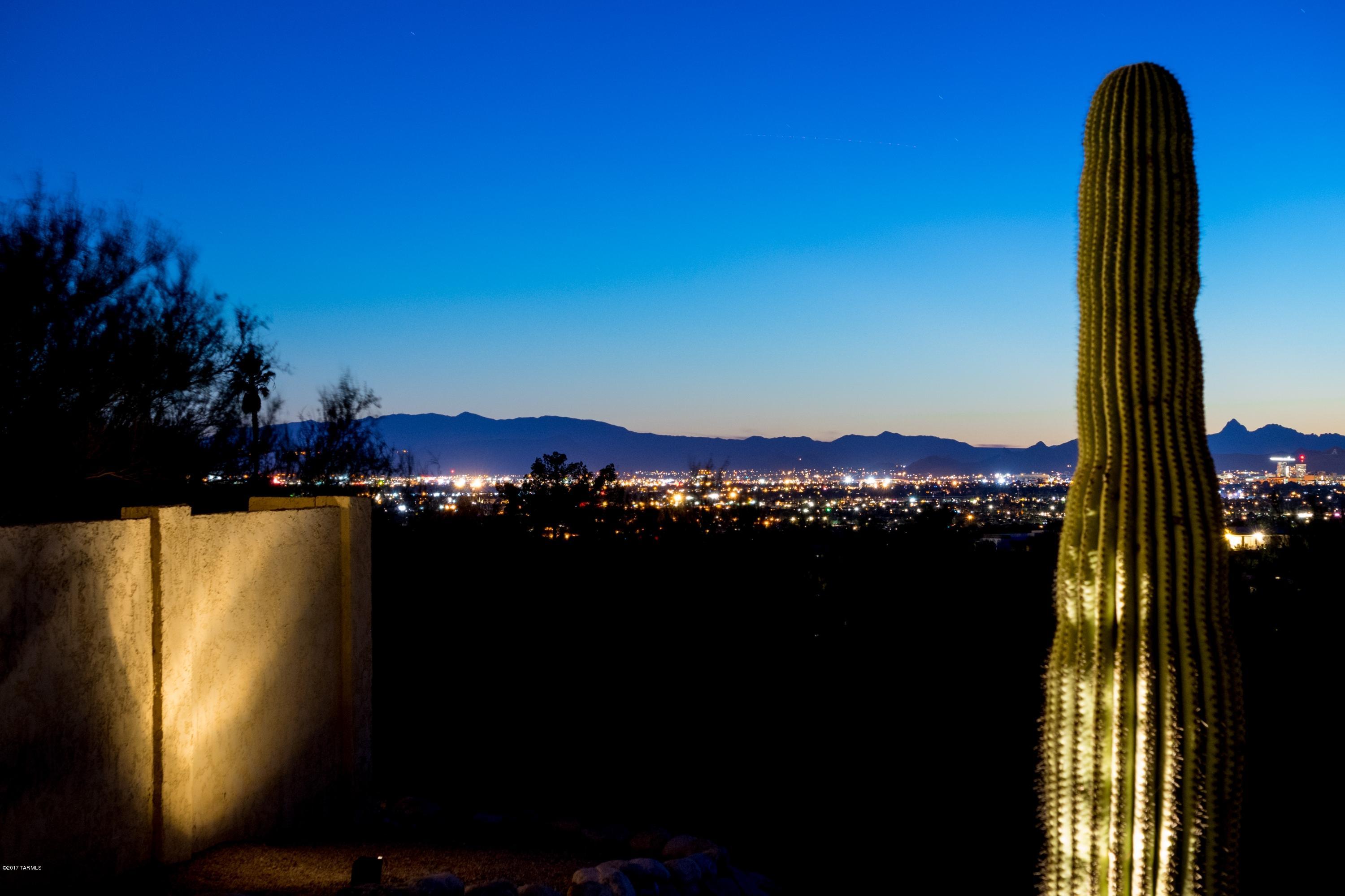 Spectacular mountain and city views await you when you visit this warm and lovely contemporary/Mediterranean home.  The updated kitchen has hickory cabinets, a granite island and pull out shelves.  The split floor plan includes an en suite guest room for extra privacy.  Patios surround the house and the recently remodeled pool has a lagoon for in-pool lounging.  Plenty of storage is available in the laundry room and the extra room can be used as a craft room, exercise room or office.  The master bedroom has a second wood burning fireplace and the attached bathroom has a walk-in shower, garden tub and a door that leads to the pool, not to mention a very spacious walk-in closet. Check out the cool drone video! Central Vacuum is ''as-is''. It has never been used by seller.
