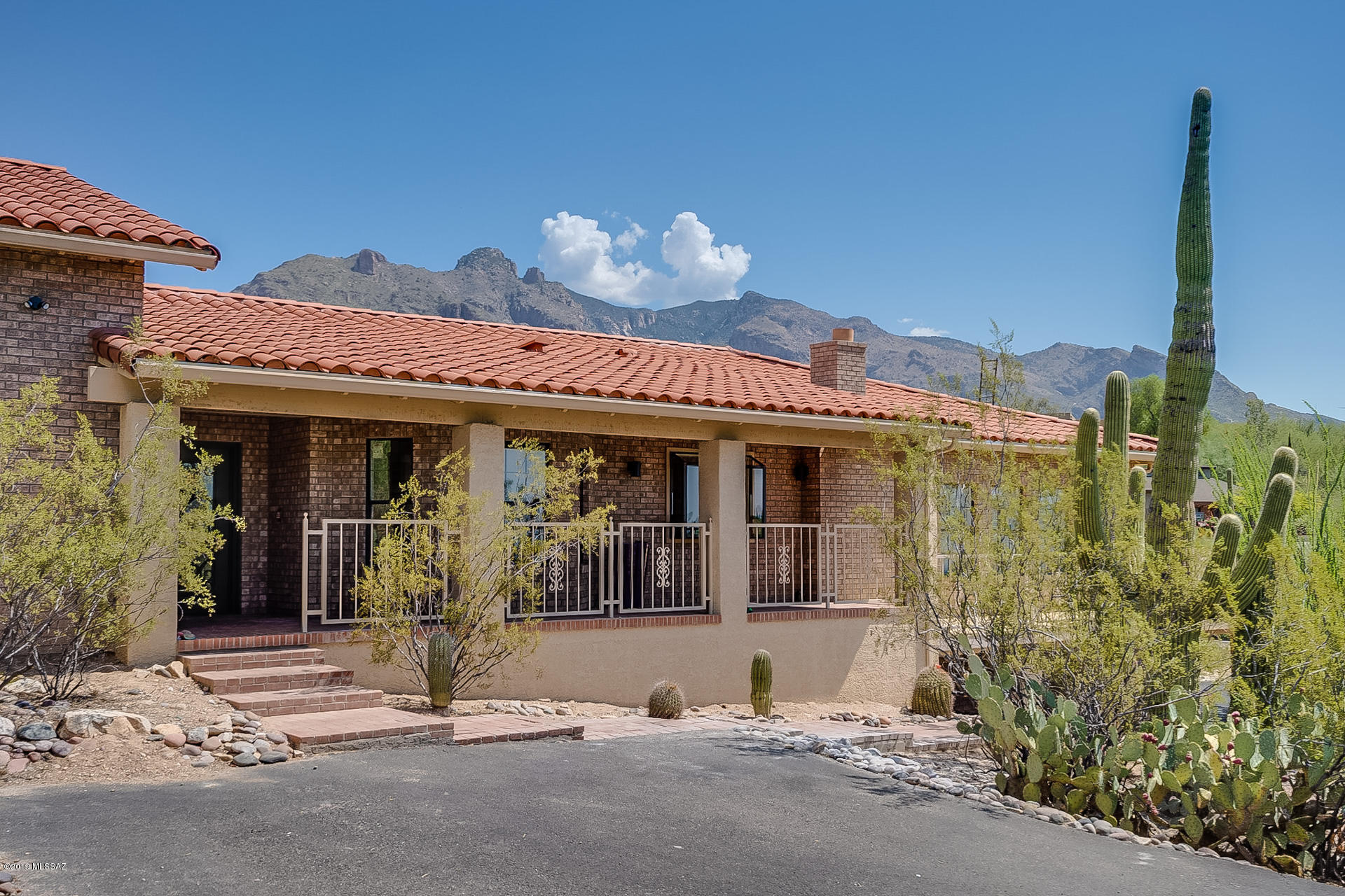 Great neighborhood of Catalina Foothills Estates no. 9, close to La Encantada luxury shopping mall, fine restaurants, upscale grocery and more! Modern style brick ranch on just under 1 acre lot at the end of a cul de sac! A 4 bedrooms, 4 bath home, seller's  just updated all the flooring with 12 x 24 neutral color ceramic tile with beautiful accented Spanish style flooring in the two main baths (master & hall baths) The master bedroom is huge (approx 20 x 20') with a wood burning fireplace and brand new flooring as well, the master bath has been completely updated with designer quality finishes. The home has a split bedroom plan! The kitchen is open, bright, and LARGE, with granite counter tops, and stainless steel appliances, cherry cabinets,    large great room with a wood burning FP . Vaulted ceilings, wide hallway leads to the 3 additional bedrooms, a hall bath, and large laundry room that has a door that leads to the pool area. Wonderful backyard that has builtin BBQ, & big mountain views of the catalina's!!