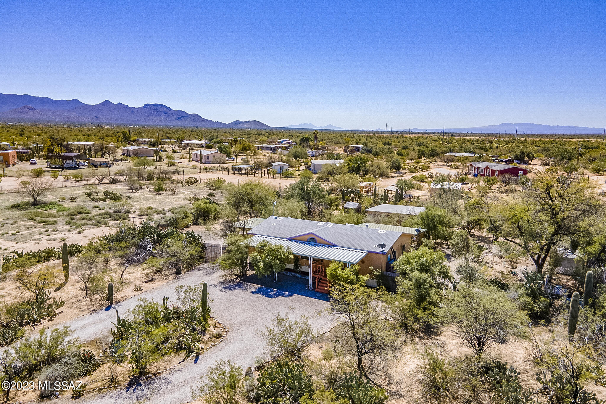 Located on 1.25 acres with mature desert, saguaros, and native trees, this private desert oasis boasts a beautifully done 1296 sq. ft., move in ready, split floor plan home with 3 bedrooms and 2 baths. Fresh paint and flooring in '20. New AC in '21. New dishwasher and oven in '22. All appliances convey including fridge, washer and dryer. Termite plan with transferable warranty. Roof inspected and repaired in '23 with transferable warranty. Covered patios in the front and back plus an attached carport. 625 sq ft workshop with electric and evap wall cooler. There is an 8x8 gardening/ storage area as well as a second 7x7 storage. Room for RV and toy parking! Garden paths to walk and multiple areas to stop and enjoy.