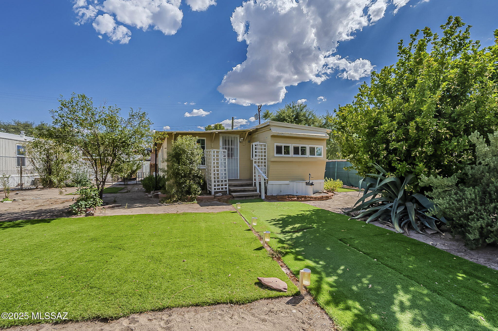 Cozy mobile home with addition and basement sitting on a spacious corner lot.   Newer stainless appliances in kitchen. Fenced yard for privacy; citrus tree in front; storage shed in back conveys.   Close to shopping and Sun Tran Bus Route.