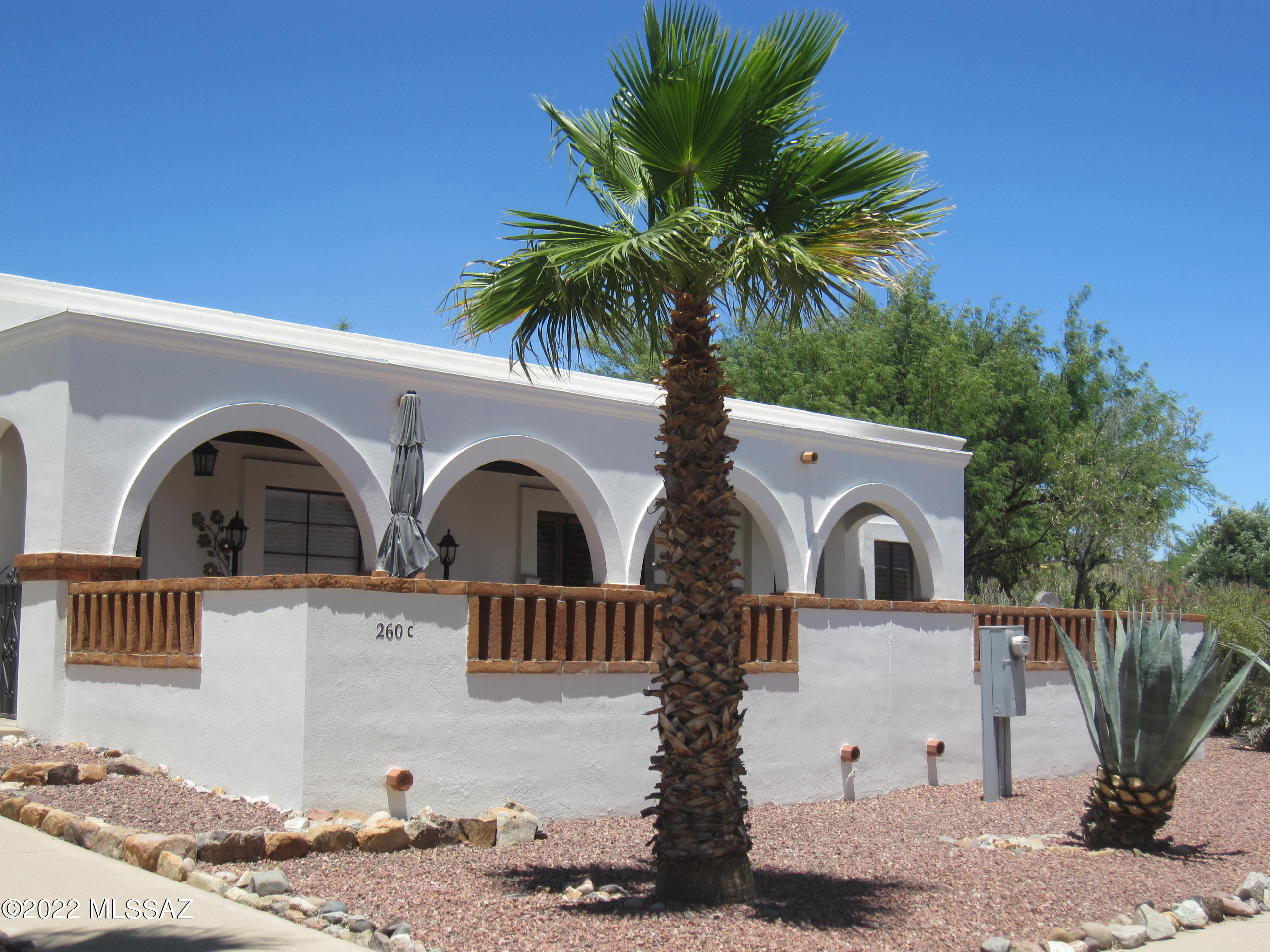 WELCOME TO YOUR NEW HOME IN THE WELL-MAINTAINED VILLAS EAST.  YOU'LL LOVE THIS END-UNIT CONDO WITH A MEDITERRANEAN DECOR  INCLUDING A RARE BEAUTIFULLY DECORATED BEE-HIVE FIREPLACE! STUNNING TERRAZZO STONE TILE THROUGHOUT PLUS PLANTATION SHUTTERS IN EVERY ROOM!  STAINLESS STEEL APPLIANCES GRACE THE KITCHEN.  BREAKFAST BAR, PANTRY CABINET AND MODERN TRACK LIGHTING!  OUTSIDE  BACK DOOR IS  STORAGE ROOM WITH STACK WASHER AND DRYER!!   CEILING FANS IN BOTH BDRMS!   GORGEOUS CABINETRY IN BATH PLUS A TERRAZZO-WALLED SHOWER!  FRONT BDRM WITH EXTRA CLOSETS.  THIS HOME IS CLOSE AS CAN BE TO SHOPS, RESTAURANTS,AND THE WEDNESDAY FARMERS' MARKET IN THE GREEN VALLEY VILLAGE.  MONTHLY HOA FEE OF $240 COVERS WATER, SEWER, TRASH, OUTSIDE MAINTENANCE, ROOF, HVAC, POOL, SPA.  ENJOY GV REC ASSOCIATION, TOO!