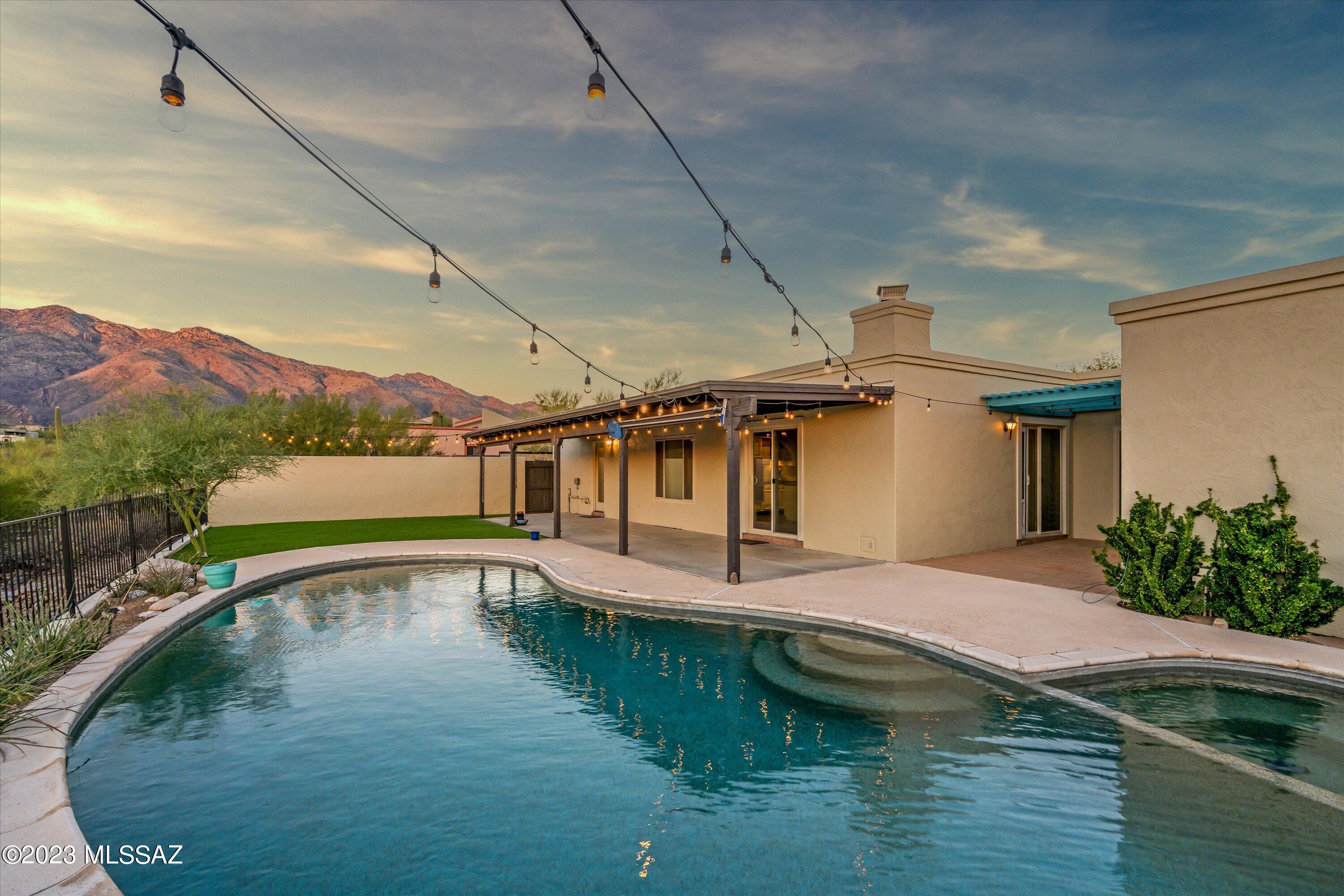 Enjoy dramatic views by day and stunning sunsets in the evening from this home's backyard located in the highly sought after Cimarron neighborhood in the Foothills! The Catalina Foothills School District is one of many attractions to this quiet, beautiful neighborhood. This home boasts several options with formal living and dining areas as well as a family room with backyard views and space to entertain. The updated Silestone kitchen counters with a farmhouse sink will be your place to create the perfect meal. With actual wood flooring in the bedrooms and living room you can create a space that is modern and also has a feel of comfort. This home has a great "mud room" off of the pool with the laundry facilities to make summer gatherings easy and comfortable for all to enjoy their day by the pool.  The PebbleTec pool is one of the many features in the back yard that makes this home an entertainer's dream. The back yard is low care with a recently installed turf--great for games, pets, or relaxing. The home's flow of space is perfect for whatever one may need to spend time with friends as well as feel at home with the family. Come see this great home today as it may be someone's new retreat by tomorrow.