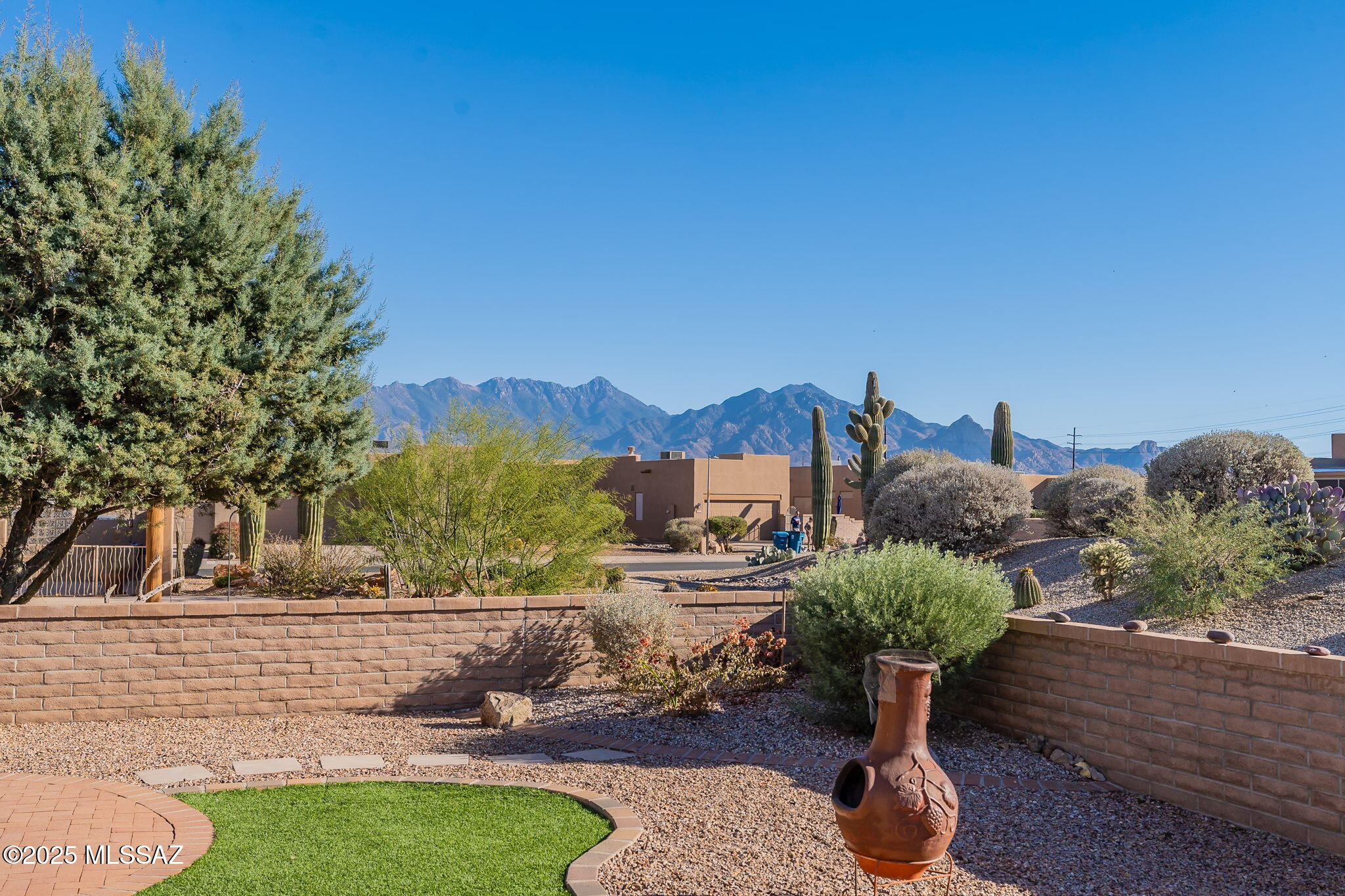 Experience the essence of Southwest living in this move-in-ready, updated contemporary home nestled within the sought-after gated community of The Springs in Green Valley. This 1,348-square-foot residence boasts two bedrooms, two full baths, and an open floor plan that seamlessly connects living spaces while capturing breathtaking Santa Rita Mountain views. The spacious great room is bathed in natural light, creating the perfect ambiance for both entertaining and relaxation. The kitchen, open to the great room, features Corian countertops, a newer electric oven, and ample counter and storage space. The primary suite is a true retreat, featuring a newer walk-in shower and conveniently located near the laundry room and a generously sized walk-in closet. The split-bedroom layout ensures guest privacy, with the guest bathroom also featuring stylish updates. A versatile den provides the ideal space for a home office or a dedicated hobby area. This meticulously maintained home has undergone recent upgrades, including newer windows, HVAC, water heater, water softener, and an epoxy garage floor. Step outside to the beautifully landscaped backyard and savor the stunning mountain vistas. Enjoy the convenience of walking distance to the GVR Recreation Center and nearby walking trails. This home is ready to welcome you!