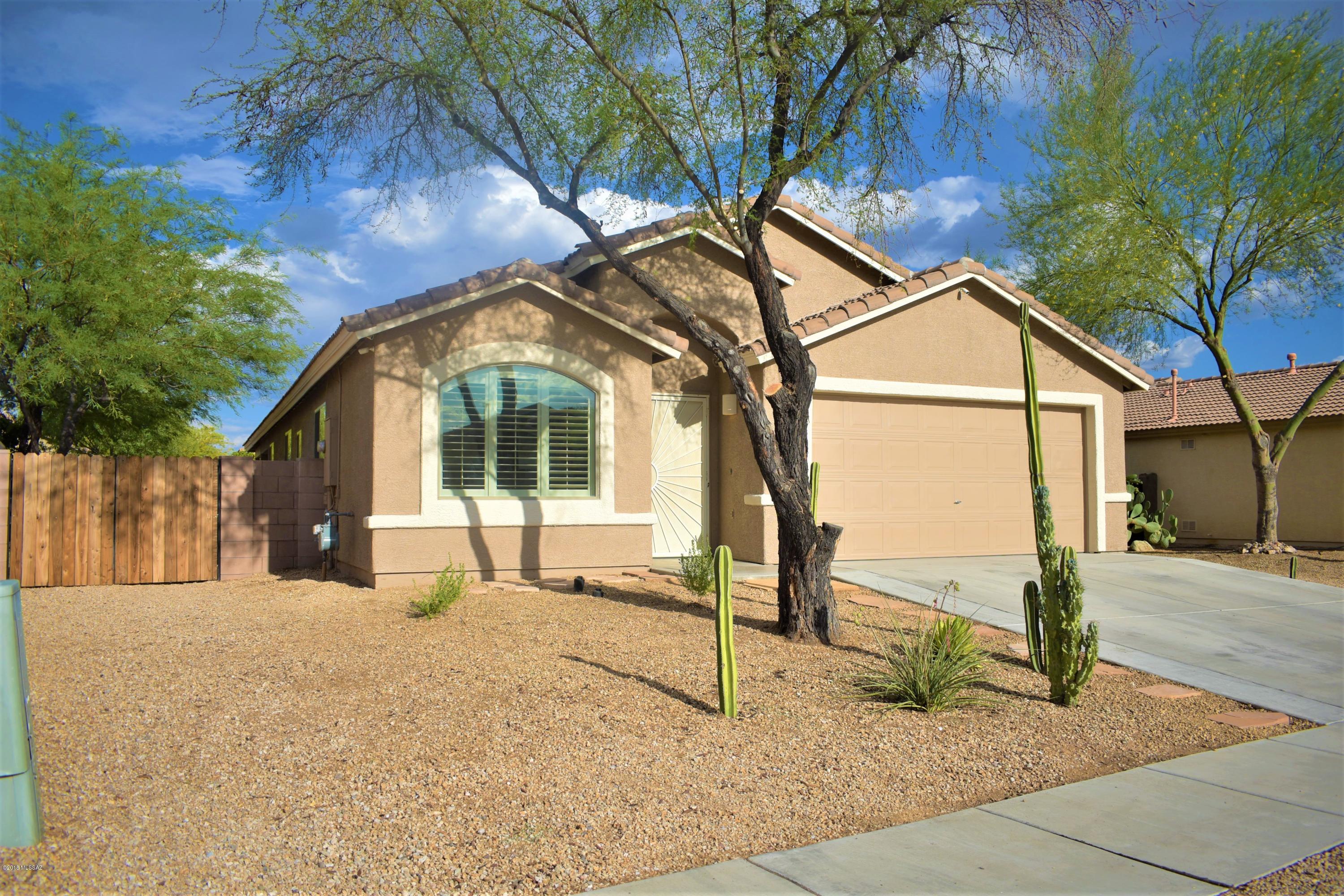 Very well-maintained home in the quiet Tucson Mountain Sanctuary neighborhood! Tile throughout, carpet in the bedrooms. Four bedrooms, two full baths. Home features granite countertops in kitchen, bathroom/laundry room. Stainless steel appliances, installed upgraded light fixtures, remote/ceiling fans, custom window coverings and security camera system. Family/great room and formal living room, large master suite with walk-in closet, soaking tub & shower.  Open feel with vaulted ceilings and arched doorways. Large private backyard features a spacious covered patio, mountain views and mature irrigated landscaping for minimal maintenance. Come check it out!