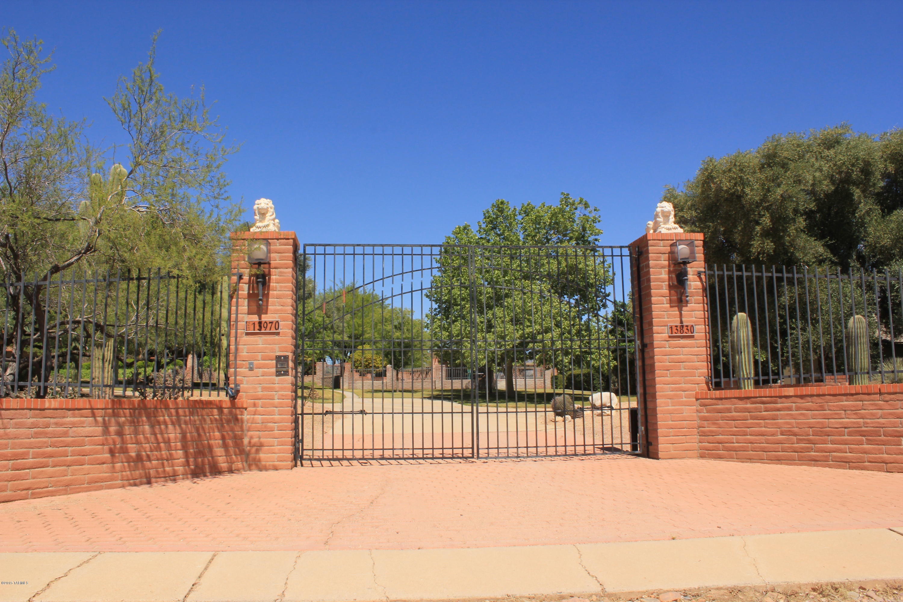 This elegant estate greets guests with its own private gate opening to 2 acres of gorgeous grounds, landscaping, mature vegetation & a long drive way leading to the covered Portico! This home hosts a 2 car garage with ample storage & roof access, a luxurious living room with a soothing heater blower fireplace, a wet bar & high vaulted ceilings, an exquisite formal dining room with a built-in China hutch & bay window, & kitchen with lots of cabinets, granite counter tops & all appliances convey upon purchase! Massive master suite includes a built in, king size headboard, large walk-in closet, dual sinks, a garden tub beautiful French doors leading to the huge 91X21 covered patio! Step out back to the Ramada & enjoy 2 built in propane BBQ grills, a drop down, wood burning BBQ, 40X20, 12ft