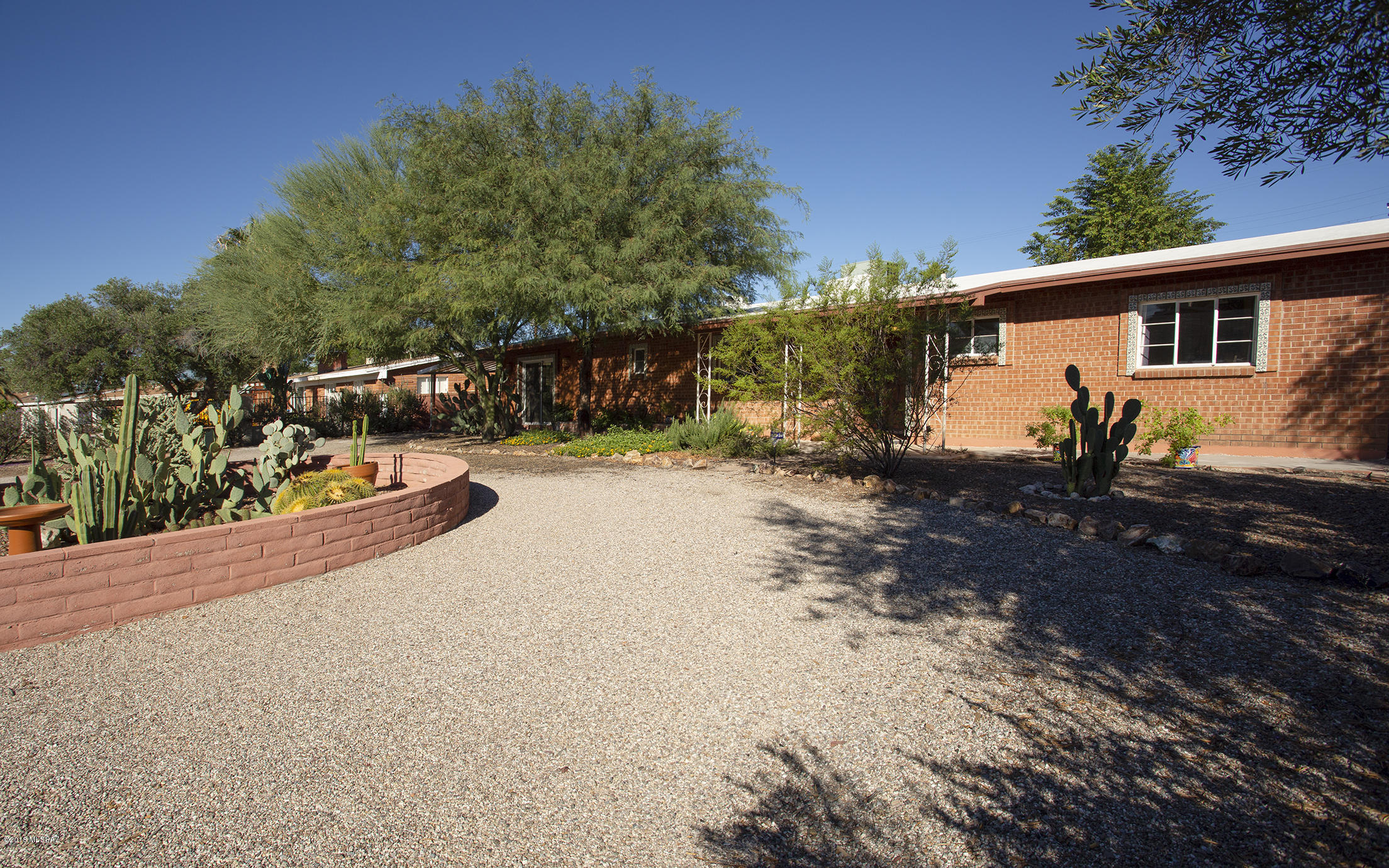 Fresh paint and tile throughout. This charming home has an open and bright living room that boasts a wood beamed ceiling and a wall of windows. Modernized kitchen offers contemporary countertops, abundant cabinetry and updated appliances. Large extra room can serve as a living room, work studio or home office with easy access to the front drive. French doors in dining area open to covered patio and fully landscaped back yard. Buyer has the opportunity to join the neighborhood pool, which is an optional membership. Centrally located and less than a mile walk to award-winning high school.  Newer roof, Plumbing and paint.