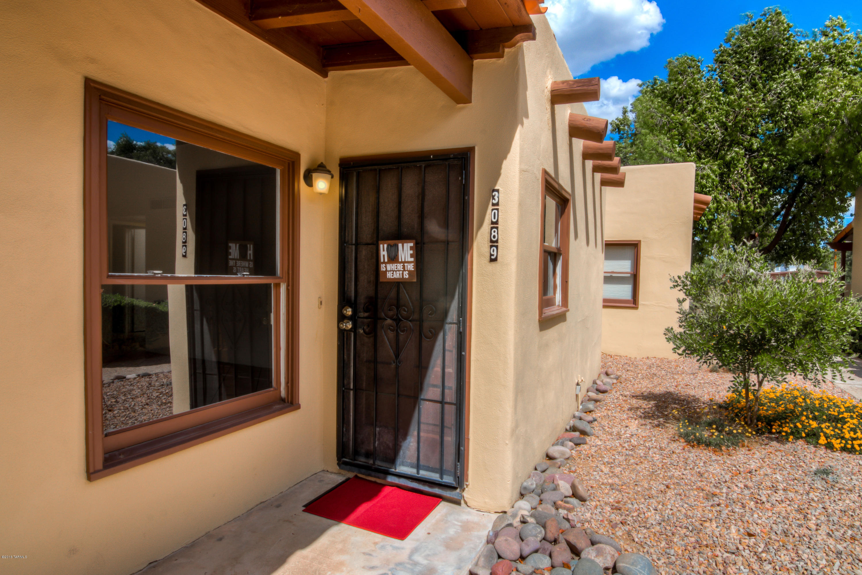 GREAT VALUE!  This charming, move-in ready, single-level townhome style condo features neutral tones, open floor plan, skylights, & super high exposed beam ceilings in the great room. Light & bright kitchen has stainless appliances, plenty of cabinets, breakfast bar & a HUGE pantry. The small, quiet community of 41 units has a sparkling pool & expertly maintained tree-lined walkways that meander through lush common areas & desert gardens. Enjoy having friends & family over to gather in your spacious & private covered back patio with mature citrus trees. Access your covered parking space directly from your back gate! Close to “The Loop” river path, bus lines, shopping, restaurants, TMC & only 4 miles to University of Arizona/Banner UAMC.