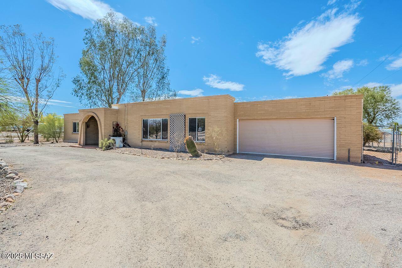 Discover the charm of this traditional Tucson home, with a spacious 0.65-acre lot with 3,345 square feet of living space, Mountain Views—and No HOA! Thoughtfully designed with character, this five bedroom, three and one-half bath home includes a private one bed, one bath casita with its own kitchen, living area and separate entrance, perfect for rental income, guests or multi-generational living.

From the elegant arched doorways to the carved wood double front doors, this home exudes charm. The inviting layout includes a family room with a fireplace, an office/flex space, and a beverage bar—ideal for entertaining. Exit outside to an expansive covered patio with a spa, where you can unwind under the stars. This property also features TWO separate two-car garages (front and back), a double gate, and ample space for parking an RV, boat, and more. The backyard is a blank canvas, ready for you to design your dream outdoor retreat.

Recent updates include new paint, carpet, light fixtures, a new septic system, and more. Don't miss this rare opportunity to enjoy space, privacy, and endless possibilities!