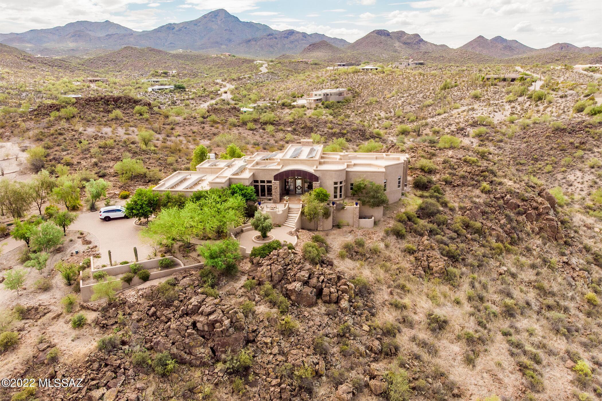 Wow! Exceptional property with solar panels, no direct neighbors behind, an entertainer's backyard, and dreamy mountain views is now on the market! Talking about a dream come true!! Exquisite curb appeal with stone accents, a mature landscape, a 3-car garage, & lots of parking space is just the beginning. Follow the paver pathway to the private courtyard with a front patio & incredible mountain views. Custom glass door leads to the bright & spacious floor plan boasting soaring ceilings w/exposed beams, pre-wired surround sound, recessed lighting, picture-perfect windows, tile flooring, a living room, & a generous-sized family room with stone-wall fireplace, media niche, & French doors to the back. Have a feast in the formal dining room! Stunning chef's kitchen showcases handsome wood cabinets, granite counters, stylish tile backsplash, wall ovens, a gas cooktop, a pantry, breakfast bars, an island, & a bright breakfast nook. Grand main suite features two large walk-in closets, a sitting area, backyard access, & a luxurious ensuite w/dual sinks. Another main bedroom owns a private bathroom. The outstanding backyard is a paradise! Exterior fireplace & an outdoor kitchen w/a built-in BBQ in the covered patio, flagstone patio, professionally landscaped, stone veneer accents, & a sparkling infinity pool, a waterfall, & heated spa complete the picture. Words don't make it justice. You must see it! Book a tour now!