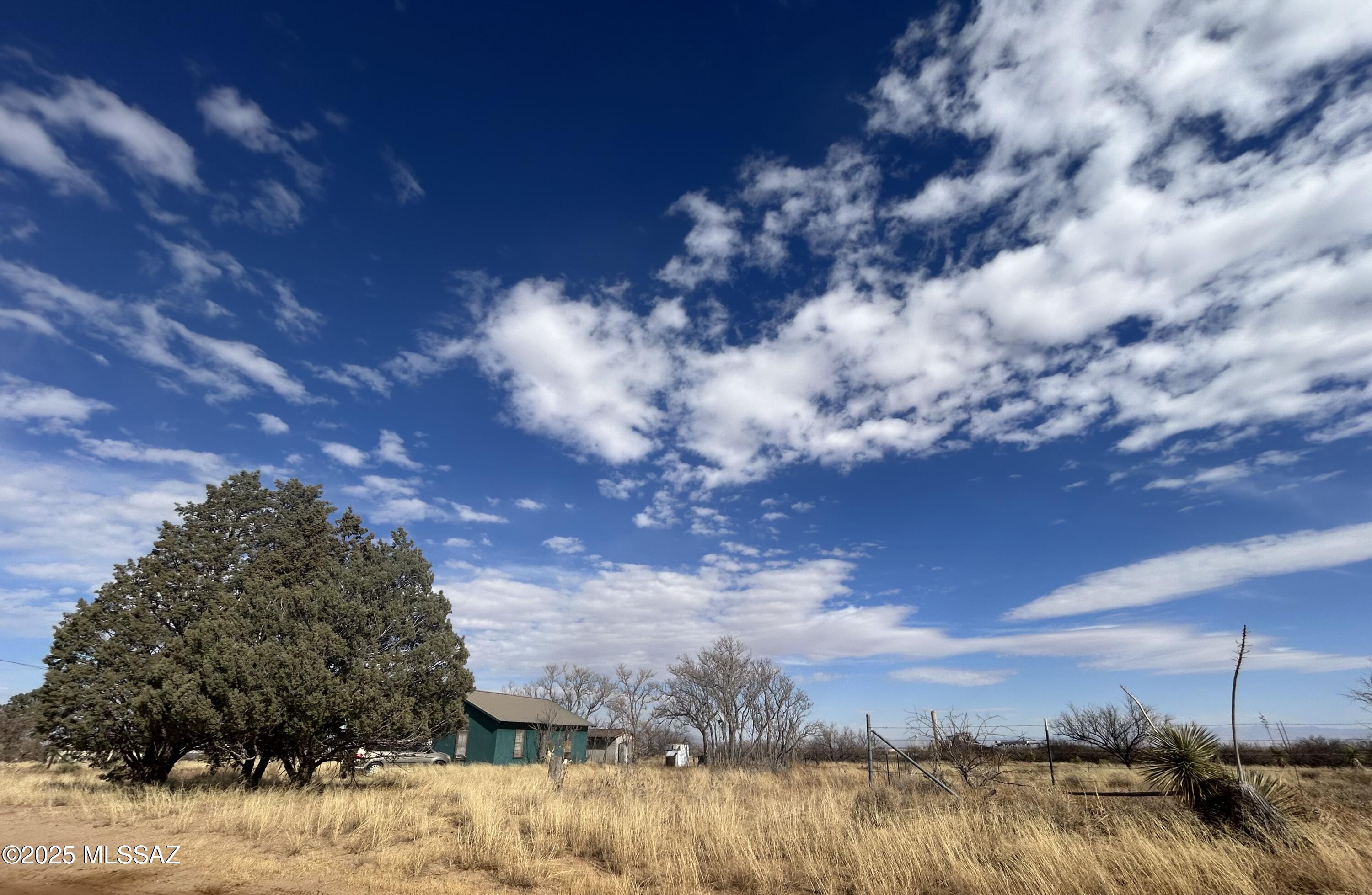 Discover the possibilities with this beautiful, nearly 5 ac parcel.  This versatile property features a private well and electric in place, a former home which can serve as an outbuilding. and shed.  This land is ready for your vision.  Don't miss this incredible opportunity to own a prime piece of Arizona land with endless potential! Private well, shed, outbuilding, structures and parcel are being sold as is, no seller financing.  Green outbuilding was a former house and is no longer habitable.  Shed has been unoccupied for a couple of years.