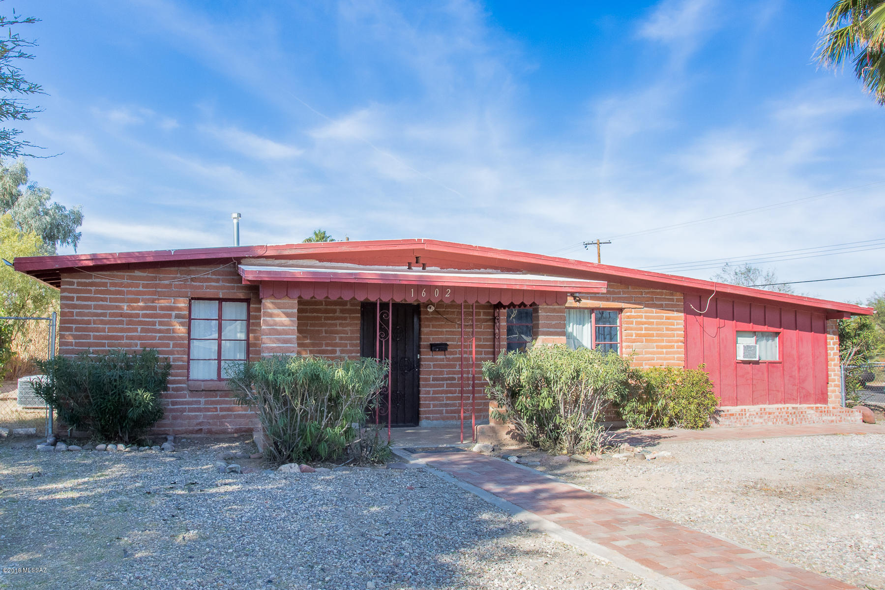 GREAT VALUE! Large midcentury home with separate guest quarters that could be a rental.  Plus a huge separate workshop (720 sq. ft.) that can be converted back to a 3 car garage.  All the heavy lifting has been done: HVAC replaced in 2015 with 5 ton Carrier unit, plumbing re-piped in 2015, electric upgraded to 200 amps, new gas lines, extra insulation in attic, roof replaced 10 years ago and recently recoated. Guest quarters has new paint and  bathroom remodel.  Indoor outdoor tile recently added in back activity room and on back porch. All appliances convey with sale of home. Large .27 acre lot.  American Home Shield Warranty included. 3/4 mile from Davis Monthan Air Force base. Tax assessor shows 1949 sq.ft.  The additional  approx. 600 sq. ft. that includes the guest quarters, office and back storage room in the house are not included in tax assessor sq. ft.   Owner selling As Is.  Owner will finance with a minimum of $50,000.  down.