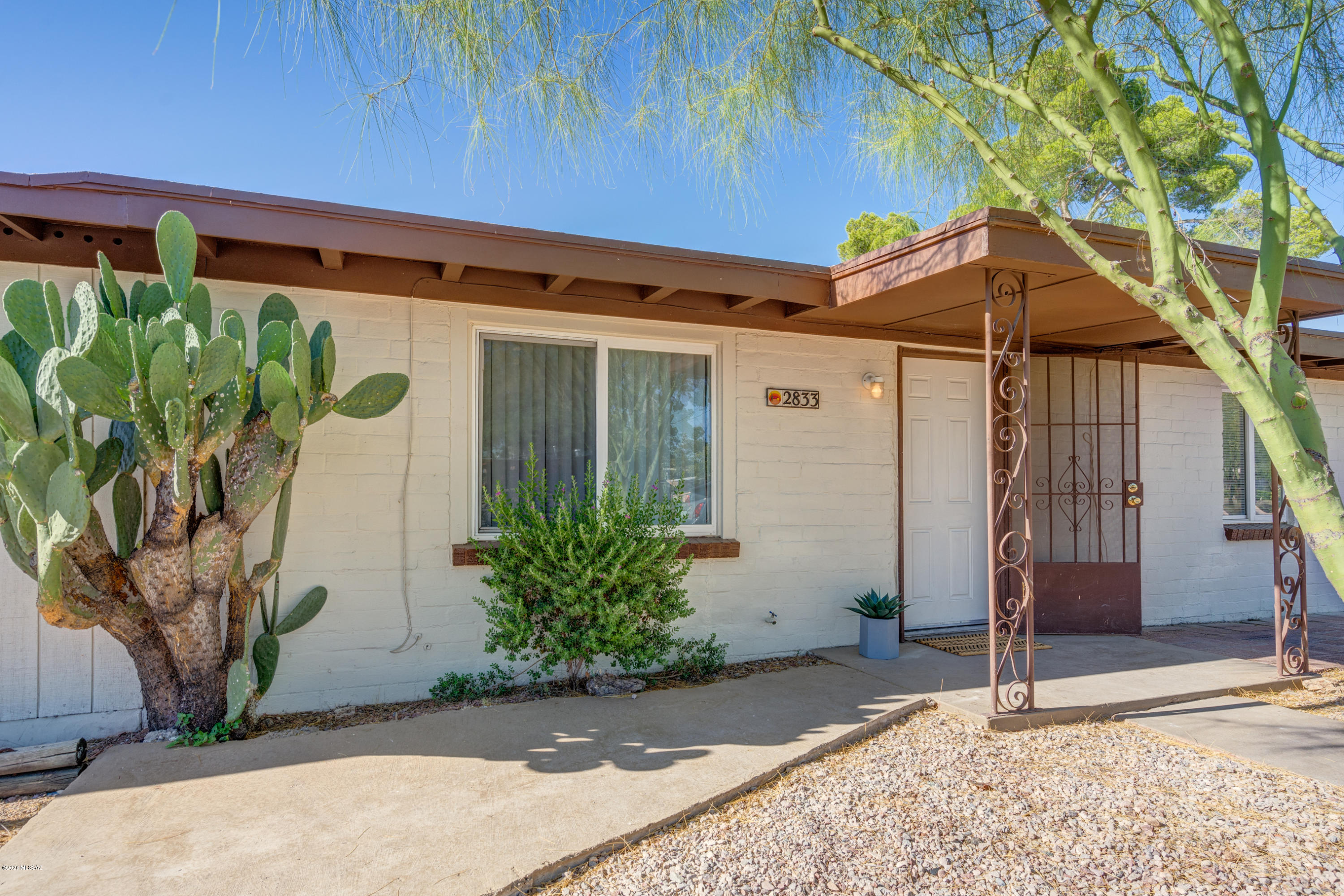 Timeless mid-century ranch home near La Madera park! Stunning wood beam ceilings welcome you inside this spacious 2 bedroom 1 bath home. Archways off the living room lead into versatile flex space perfect for office, rec room, den, you name it! Beautifully renovated kitchen offers new cabinetry, new granite countertops & a dual sink with upgraded kitchen faucet. All windows have been updated, new window shades, newly tiled tub/shower, with freshly painted interior & exterior. Relax in your huge backyard with mature desertscape, a full-length patio & lighted laundry area. Gated side yard perfect to create a dog run or garden. Plenty of parking and No HOA. Located just 3 miles from UofA & Banner: close to parks, hospitals, shopping & restaurants with a BikeScore of 98!