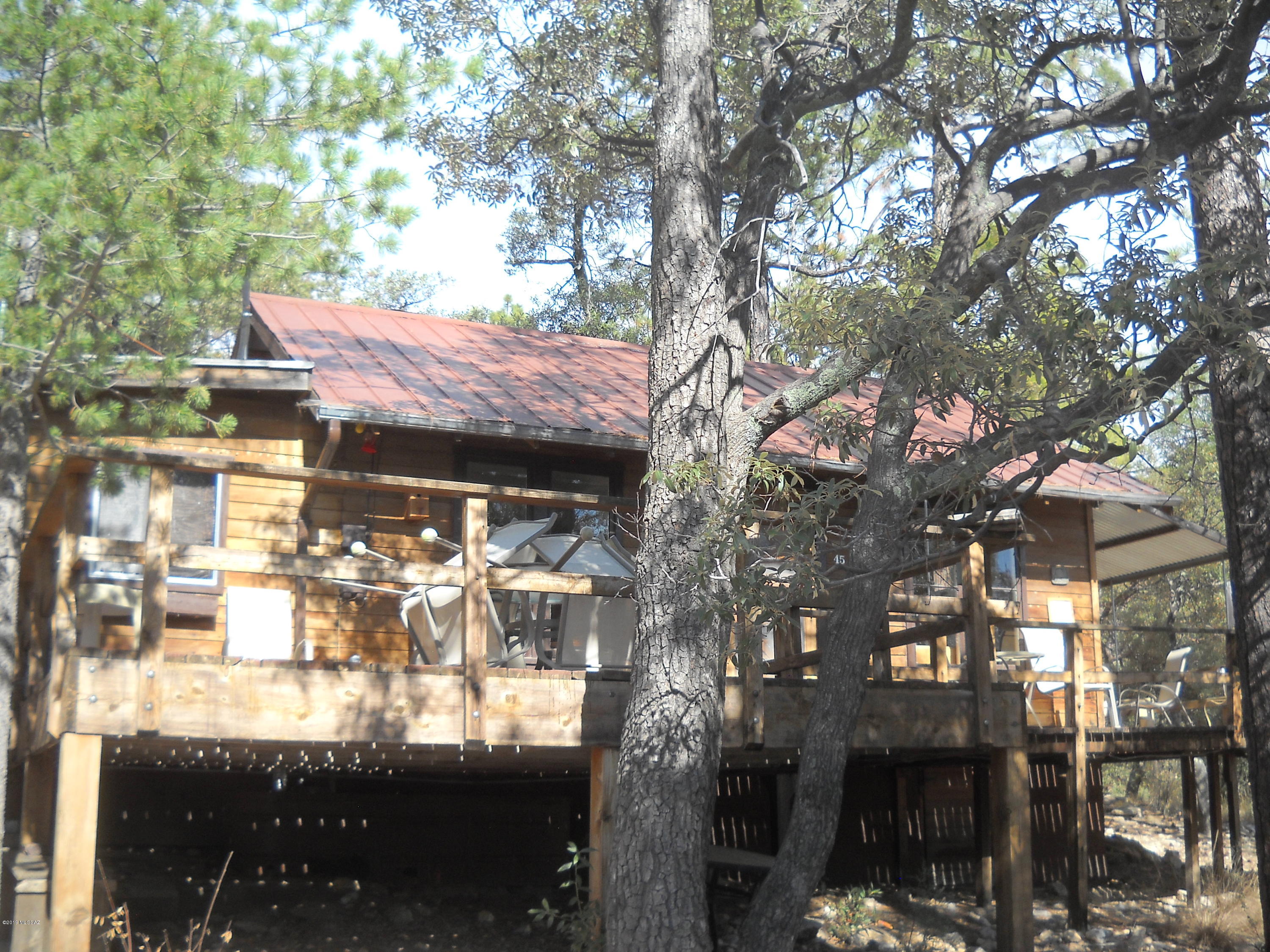 This is an original, classic 1950's cabin with historic charm. Perfect for indoor and outdoor living. Water harvesting in the area. this cabin has a 2000 gallon storage tank. Cabin is one large room with kitchen, dining, bed area, great room with fireplace, plus a seperate bath with shower, compost  and two closets.  Wonderful private setting in a pine forest with excellent mountain views. Great hiking trails, close to excellent climbing location. A short walk to Rose Canyon lake. This is a US Forest Service area where you buy the improvements and lease the land from the US Forst Service.