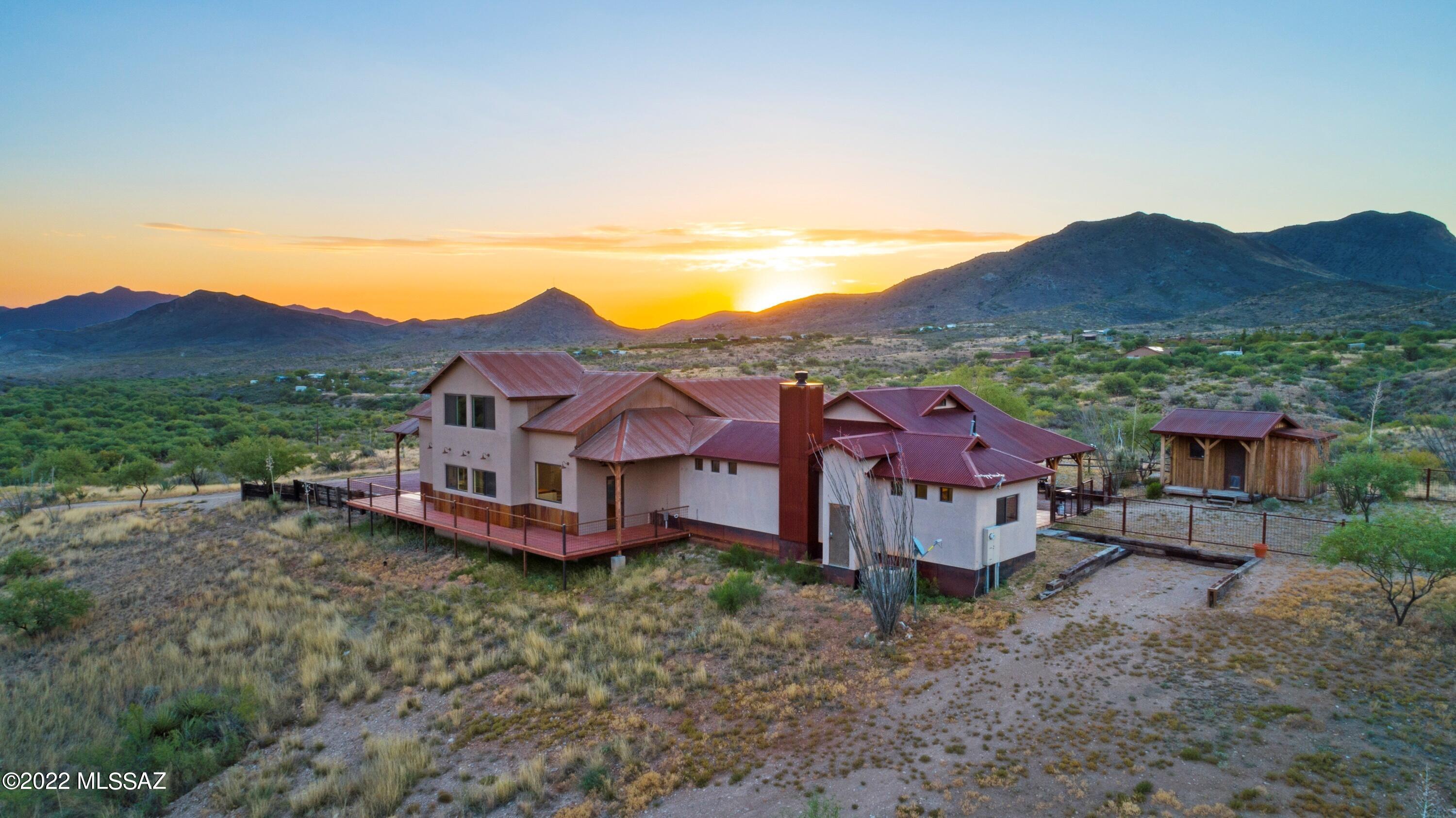Are you ready for private living? Maybe making a destination bed & breakfast, venue, or even start your own vineyard? This one of a kind, Architecturally Designed Country Ranch House is nestled in Santa Rita Mountain Foothills. Located off Arizona Highway 83, scenic Patagonia by-way, this slice of rural paradise sits on over 9 and half acres of desert mountain landscape. Recently constructed, this custom home brings you luxury amenities with design elements that perfectly blend into nature. Looking for a home with 360-degree views from anywhere in the home? You've found it. Watch the sunrise from the primary bedroom or step out and enjoy from your private patio that joins the courtyard. As the day wanes, sit on the wrap-around deck or head up the spiral stairs and sit in the loft to watch the final setting rays in the western sky. 

The main home offers an open concept living space with soaring ceilings, modern farmhouse designs, and a bright, spacious kitchen that blends raw materials of concrete countertops and reclaimed wood ceilings, crisp white cabinets, and black stainless steel appliances. Attached to the main home is a gorgeous Guest House. This portion of the home can be independent of the main home to act as a true guest space or even be used to generate short or long term rental income. Complete with kitchen, laundry, living room, bedroom, and bathroom, you can comfortably house your family, guests, or vacationers looking to enjoy a taste of the Wild West.
This phenomenal property does not end there, horse facilities, a greenhouse, vegetable garden, plumbed bunkhouse-style storage shed, and not to mention the 30'x40' double door workshop/garage. This workshop is detached from the home and gives you the perfect space to run a home business, restore a classic car, or simply store those fun toys for getting around the 9 acre property. Either way, you will never look for more storage space again.
A short drive to city amenities, local vineyards, and the recreation of Southern Arizona. Proximity to the AZ Trail for miles of riding and hiking. Escape the summer heat and enjoy the cooler temperatures of a 4000 ft. elevation. Do not pass up the opportunity to have your own Home on the Range and stunning panoramic views.