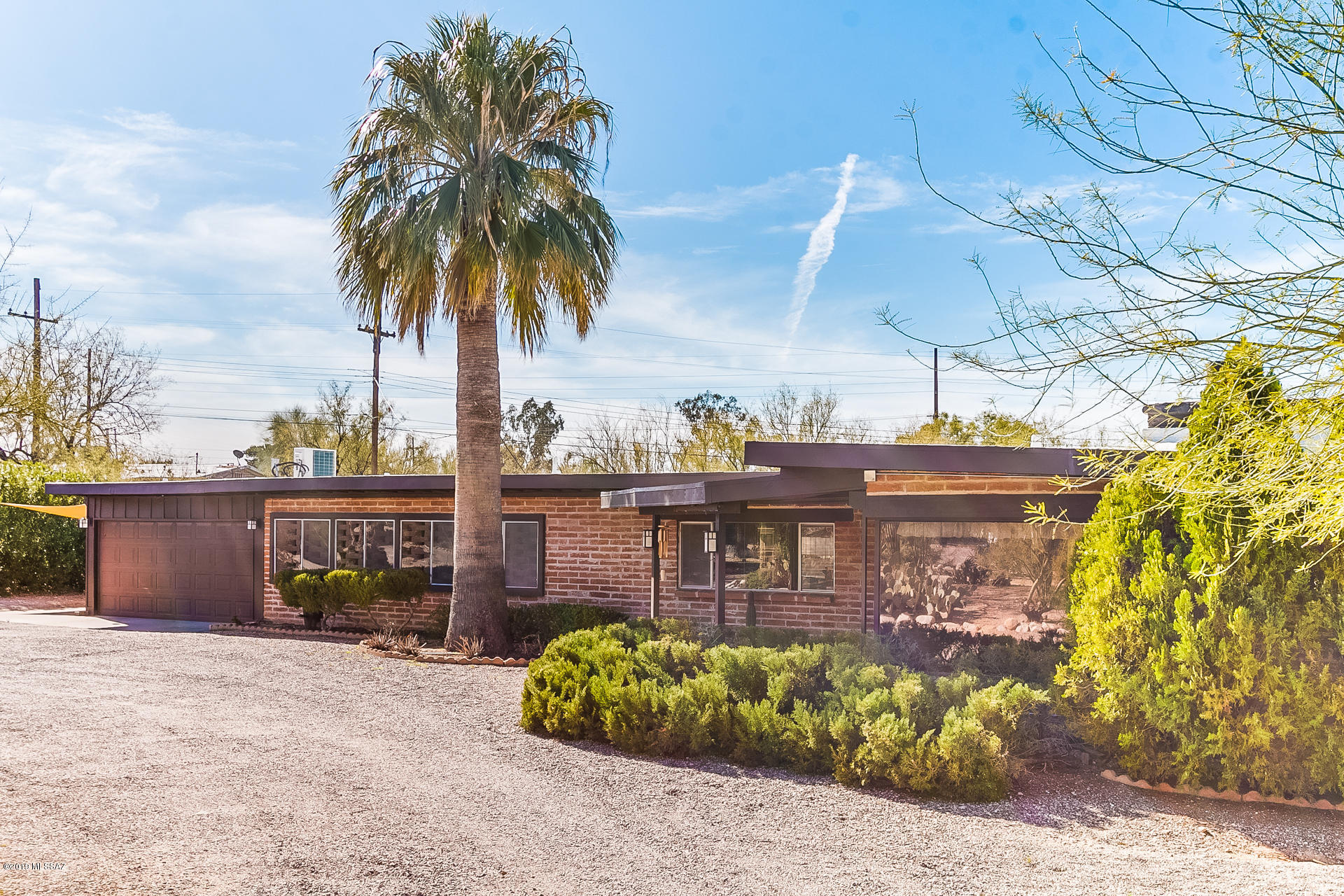 Fully renovated Adobe Ranch home in NW Tucson. This private residence comes with over 2500 sq ft. of modern mid-century charm. It has almost an acre of land with mountain views, a BRAND NEW air conditioner, and NO HOA.  Gorgeous 3BD/3BA home with a circular driveway, tons of upgrades, covered front entrance patio & views of Catalina Mountains. Incredible gourmet kitchen w/double ovens, granite counters, cherry cabinets, separate bar w/raindrop glass cabinet doors; Massive living Room w/fireplace & wall to wall windows that frame Catalina Mtn views with a rolling shutter; Spacious Rec Room/Office/Family Room w/bar, full bath & 2017 mini split system that could be turned into a 4th bedroom. Master suite includes a huge walk-in shower, antique dresser sink & vanity. Very Private backyard oasis with a covered patio, sparkling pool & outdoor kitchen. 3 car extended garage w/ additional covered parking, 2016 Water Heater, Copper plumbing, Rojos stained concrete floors & tile throughout...a true historical GEM of a property, come see today.