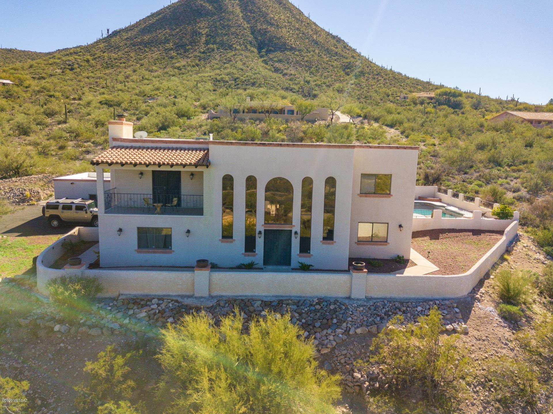 West Side Gem presenting luxury inside & out. Masonry construction on a desert oasis. Sits on a private acre of property w/ breathtaking mountain views, a greenhouse, covered patios & a sparkling private pebble tech pool w/diving board. Inside has tasteful finishes & timeless charm from wall to wall. Sunken formal living room with soaring wood beam ceiling and double staircases. Spacious den w/ french doors & built-in shelving. Spacious family room features a charming brick fireplace. Stylish gourmet kitchen with white granite countertops and backsplash, stainless steal appliances, a wine rack and wine cooler, and a large island with breakfast bar. Master retreat includes balcony offering majestic mountain views and all new remodeled bathroom & walk-in closet. Newer carpet & fresh paint.