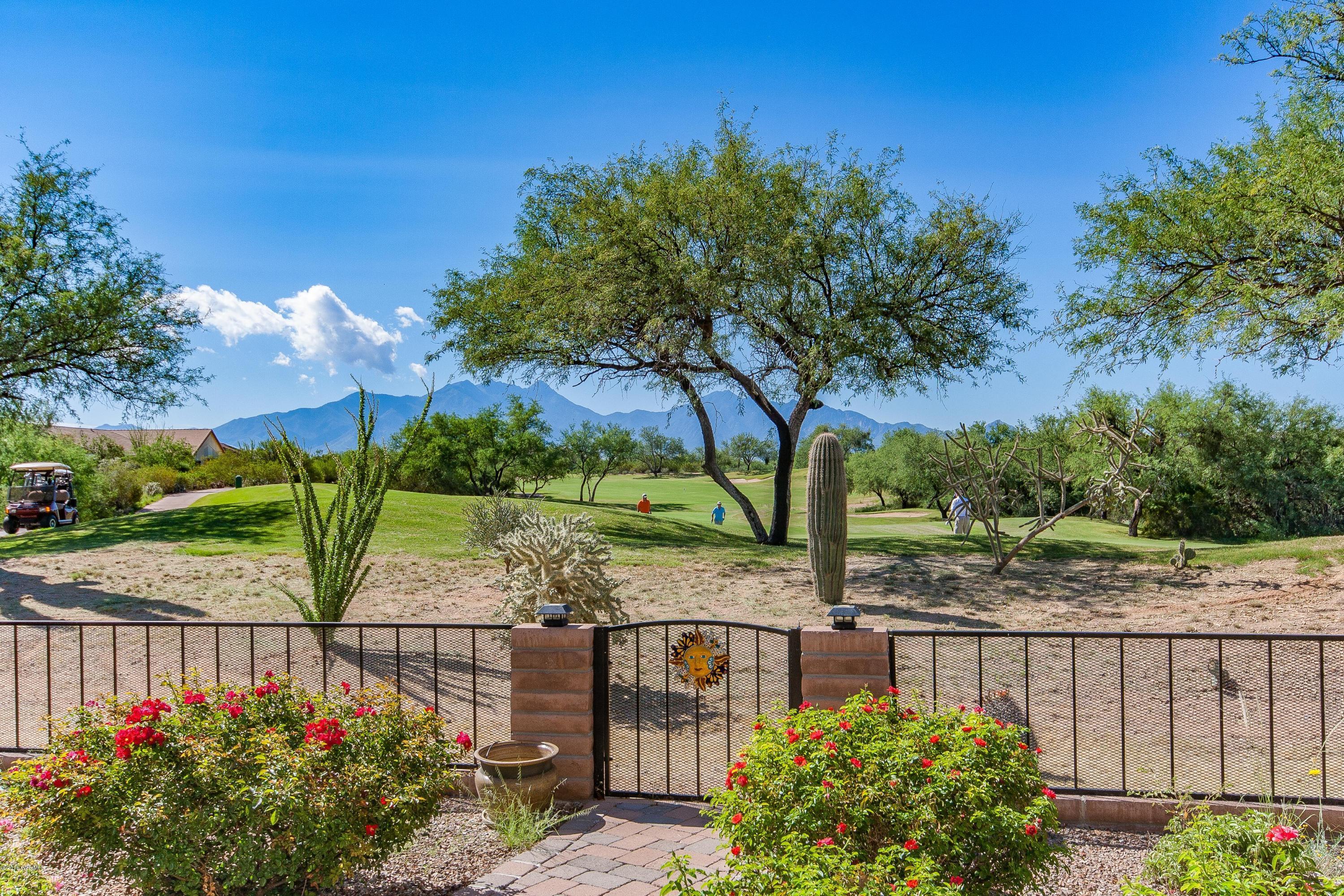 A million-dollar view for under $400,000. This Newport retreat was built with a sophisticated sensibility and has been fastidiously maintained. Glorious, unobstructed views of the Santa Rita's and the 4th hole of the Quail course. Flagstone walkways lead to the fenced backyard with pond and fountain, large brick patio with stone bench, Ramada with overhead fans/lights and pull-down shade. The backyard patio slider leads into a spacious, wide-open kitchen, dining area and great room. The centerpiece is a stunning stone wood-burning or gas fireplace set between custom-built bookshelves w/dim lighting and cabinets. Other upscale features include a kitchen RO water system, instant hot water, Hepa ceiling air filter, granite kitchen counter tops, tiled back splash, upgraded dishwasher and  s/s sink, pendant lighting, and high-end fans w/lights. Easy-care, elegant plantation shutters embellish every window (dual-paned). Open them for that fantastic view all across the back of the house. Even the front door is impressive! Come inside and you're greeted with designer tile and accents, a solar tube that floods in light and a custom hall closet configured with extra storage. You'll love the spacious carpeted master suite and master bath with dual sinks, tiled shower, high toilet and a walk-in closet with built-in ironing board and solar tube. Did we mention the view? Easily seen from the master bay window. A large carpeted den has shuttered doors and the guest bedroom, with another bay window, has a full bathroom just a few steps away with high toilet and tiled shower.