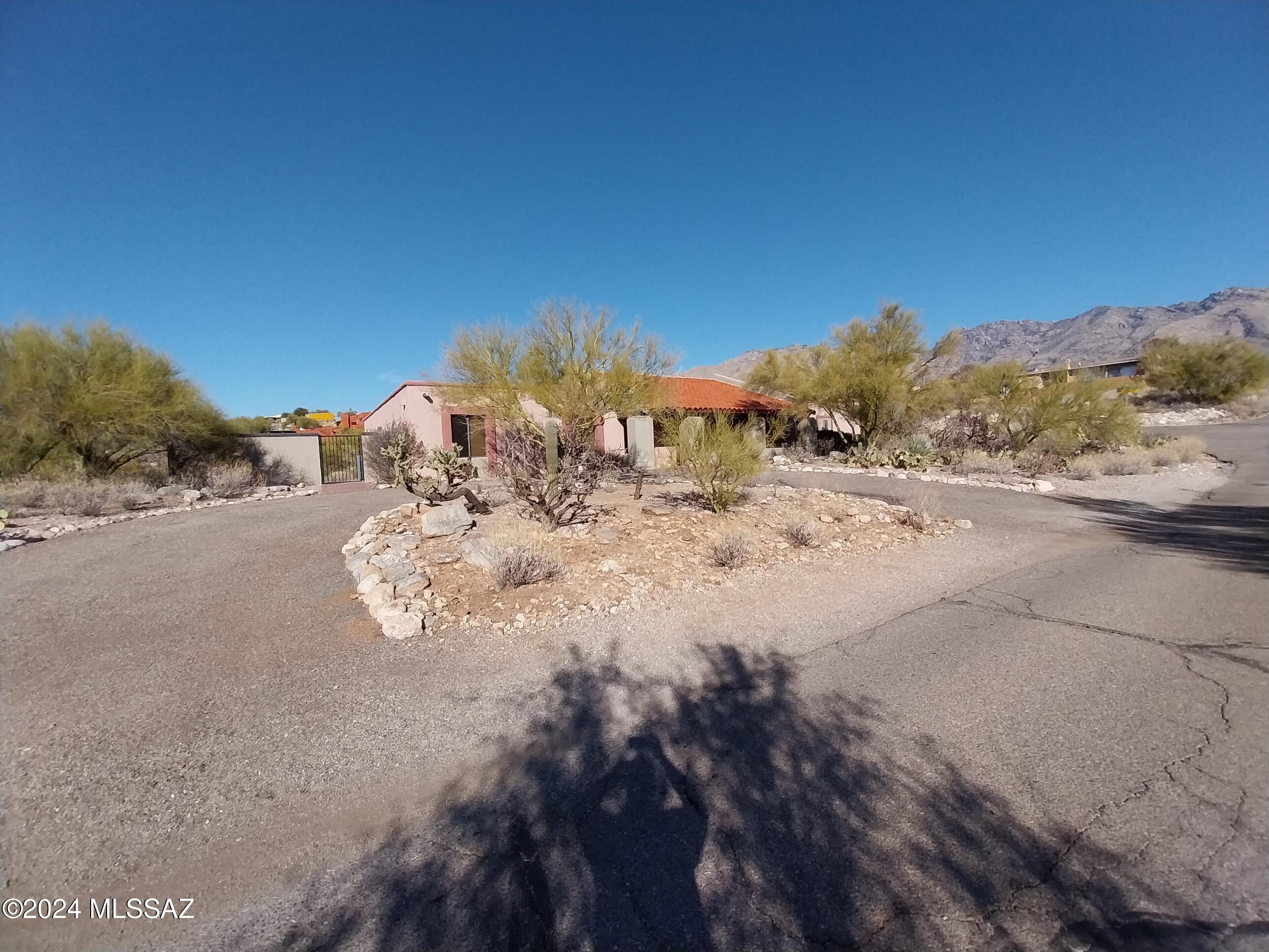 Welcome to this special home in Cimarron Estates high in the Catalina Foothills. Perched on an elevated corner lot, the property enjoys nice mountain views and fantastic sunsets from its covered porch and backyard. The large family room has a wet bar, fireplace, and is conveniently central to the home. The kitchen features dual ovens, granite countertops, and close access to the formal dining area located in the large living room. Featuring a spacious master with sitting/office area with an updated bathroom with high end designer tile finishes. Three additional nicely sized bedrooms and two guest bathrooms round out the living spaces. Includes a two car garage, washer/dryer, and additional storage. Backyard is fully fenced & has a in ground flush mounted trampoline. Dist 16 schools