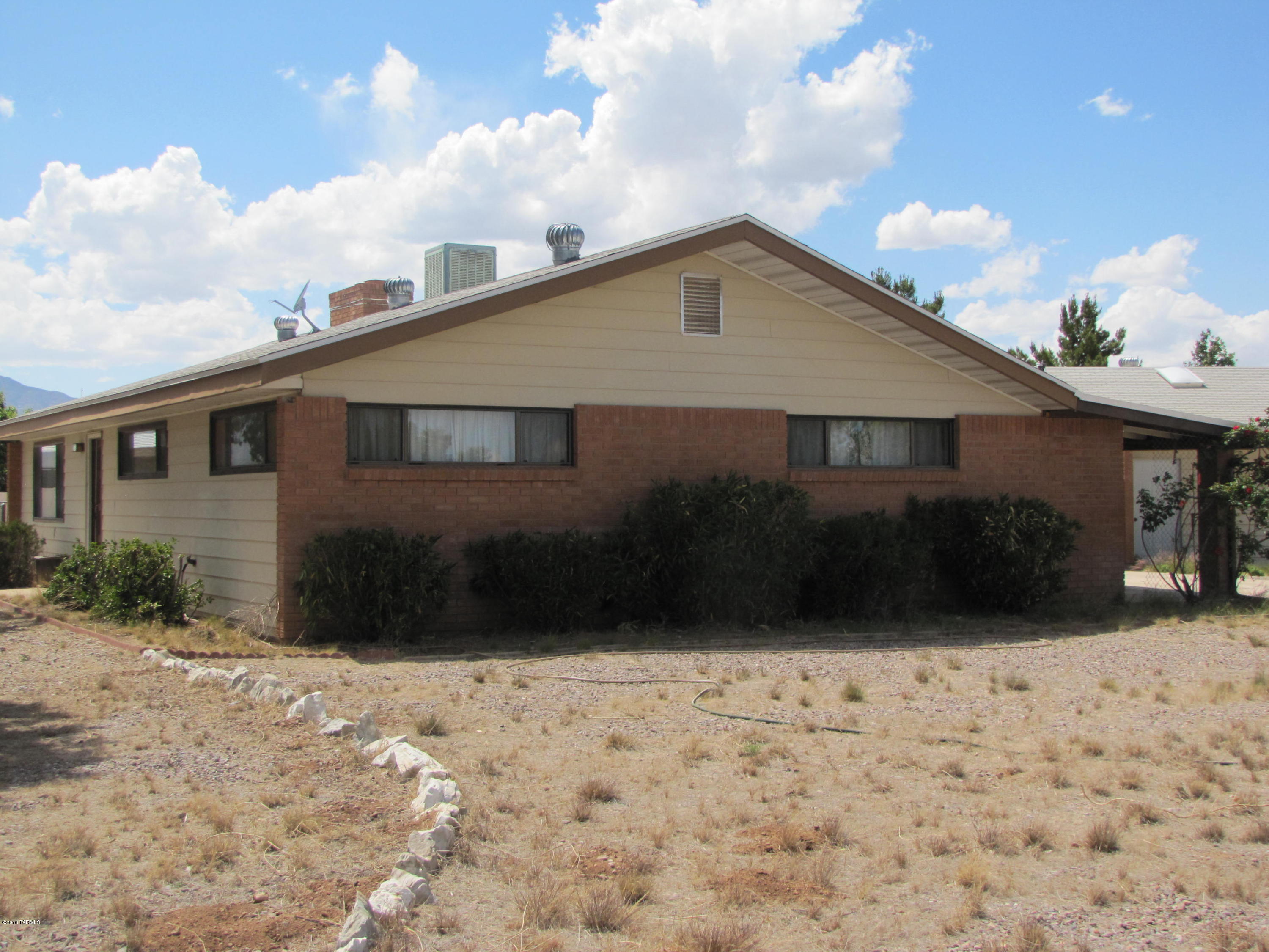Lots of floor space in this 3BR/2Ba home with 4 car garage on a larger corner lot. Open floor plan with kitchen and great room containing wood stove and bar, flowing into family room with FP. Breakfast bar and skylight in kitchen along with newer stove. New electric furnace in 2016. Covered front patio, fenced back yard, and alley in back. Garage has loads of storage space and workbench with roll-up doors on front and back. Property being sold 'As-Is' and no SPDS provided.