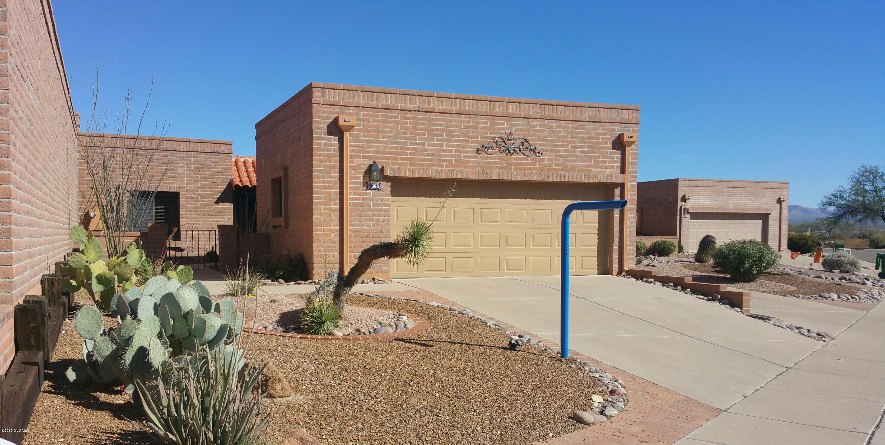 Located in Canoa Hills Townhomes, this home has a traditional territorial design with red brick curved architecture, a front courtyard and indigenous landscaping. Relax in the comfort of this oversized great room offering wall to wall plush carpeting, two radiant skylights over the dining area and a wall of glass sliding doors drawing in desert views and a cozy corner fireplace for those cool evenings. The spacious kitchen has a skylight which adds lots of natural sunlight and is equipped with abundant counter space, stainless appliances and a built-in desk area. The huge and serene master bedroom suite has oversized sliding doors providing great views and easy access to the patio. An extended low maintenance back patio means more room for relaxing and entertaining with less time  doing yard work. Backing up to the wide open spaces gives you the added privacy of a natural setting combined with beautiful desert and mountain views.