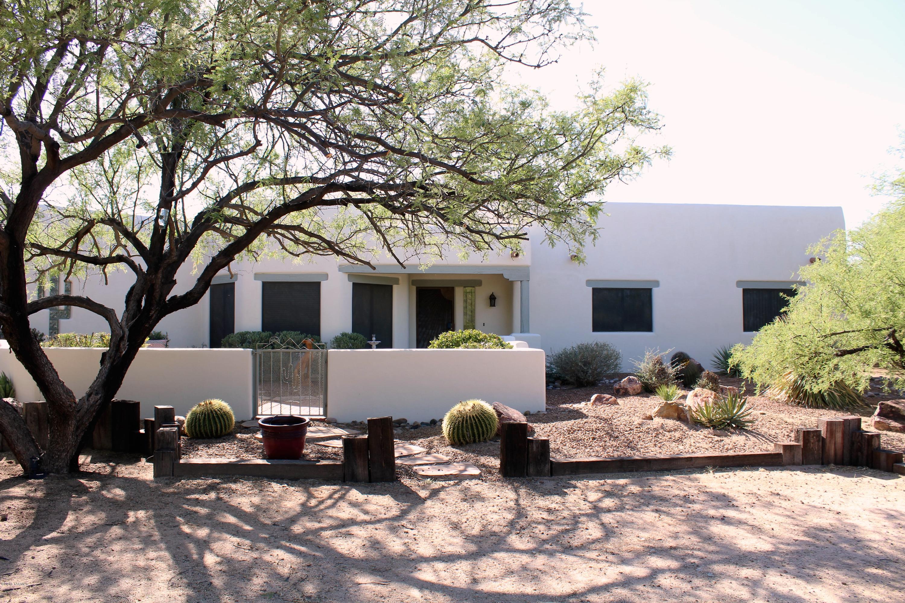 An oasis in the desert! This lovely 3 bedroom 2 bath home is nestled away on an acre parcel of land, yet conveniently located near freeway access and shopping. Walk into the custom built home and find a large living room with vaulted ceilings lined with beautiful wood beams and a 2 story wood burning beehive fireplace. An office/den/studio space in the back of the home offers a flexible option for additional space. Light flows in from the clerestory windows and the large slider that brings your eye to the lush back yard. Outside you will find a private and inviting pebble tec pool, specialized K9 artificial grass and multiple patio areas for enjoying the amazing desert landscaping. With a acre of property and no HOA, you have room to park an RV or add a workshop. Don't miss this one!