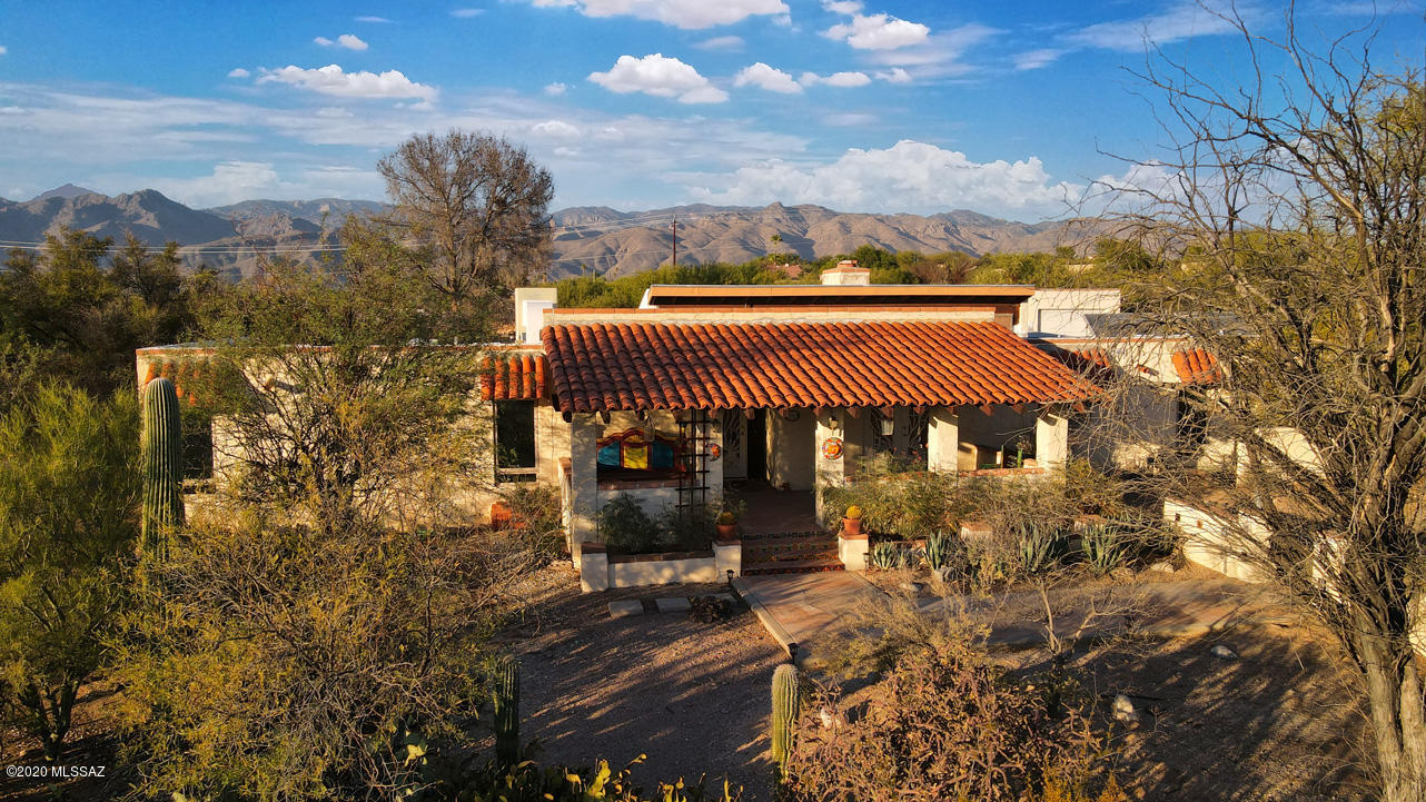 Tucked away in a lovely cul-de -sac, this charming hacienda is ready for its new owners. Enjoy sweeping mountain views and handsomely remodeled features in this East Side hidden retreat. The broad covered front porch, accented with authentic Talavera tiles, is the perfect spot for an aperitif...unless you prefer that fabulous rear yard overlooking the gorgeous salt water pool and spa, extensive brick patios, raised garden beds, a long covered terrace and authentic stucco beehive fireplace, not to mention the expansive views of the Catalina Mountains, so gorgeous at sunset. It's really a slice of ''Old Tucson'', ready for relaxed enjoyment. The airy kitchen, with a skylight for extra light, has been tastefully remodeled with newer cabinetry that includes under-counter lighting and pullouts in lower cabinets to keep your back happy. Newer slate-shaded appliances include a gas range with four burners and a griddle. Behind the kitchen is a laundry room and large pantry room that leads to the 4-car carport with additional storage in the rear. The adjacent cozy family room has clerestory windows for natural light and a beautifully remodeled two-way gas fireplace with tile facing including a lovely inset "quail" design. The other side of the fireplace is in the living room, a delightful sitting spot with enchanting mountain views. The adjacent dining room has southwestern double doors leading to the broad front porch, perfect for a breeze on a nice evening. The owners' suite has similar doors opening to the pool area, lovely views and a remodeled glass-front large walk-in shower with a bench. Master Bedroom suite plus two additional bedrooms share another full bath plus a den or office. All flooring has been replaced with handsome large ceramic tiles that have artistic insets separating the various rooms...no carpet! There is a large storage shed in the rear area, and a detached garage with workshop space and 220V. electrical line is nearby. All windows are dual-pane. Ceiling fans abound. The area is close to all services, shopping and good restaurants. We invite you to call soon for an appointment to view this lovely retreat.