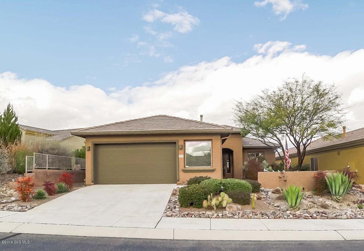 A beautiful Bonita model floor plan that is sitting high on a hill overlooking the Canoa Ranch Golf Course where you can also appreciate views of the Tucson Mountains miles away to the north. Beautiful river rock and indigenous shrubbery decorate the front landscaping which includes a Flagstone front courtyard that makes a wonderful place for coffee and conversation with neighborhood friends. When you walk into the great room you will notice the beautiful diagonal ceramic floor tile, wide open floor plan and arched gateway passages. A cook's delight kitchen with an abundance of cabinets and countertops, double door pantry plus a convenient breakfast nook. The open area adjacent to the great room can be used for either a formal dining room or an office/den area. Your master suite  has walk-out patio access and the bath features his and hers vanities and built-in makeup station. Built-in workbench in this oversized 2.5 car garage. Relax on your extended covered patio and enjoy expansive views in every direction!