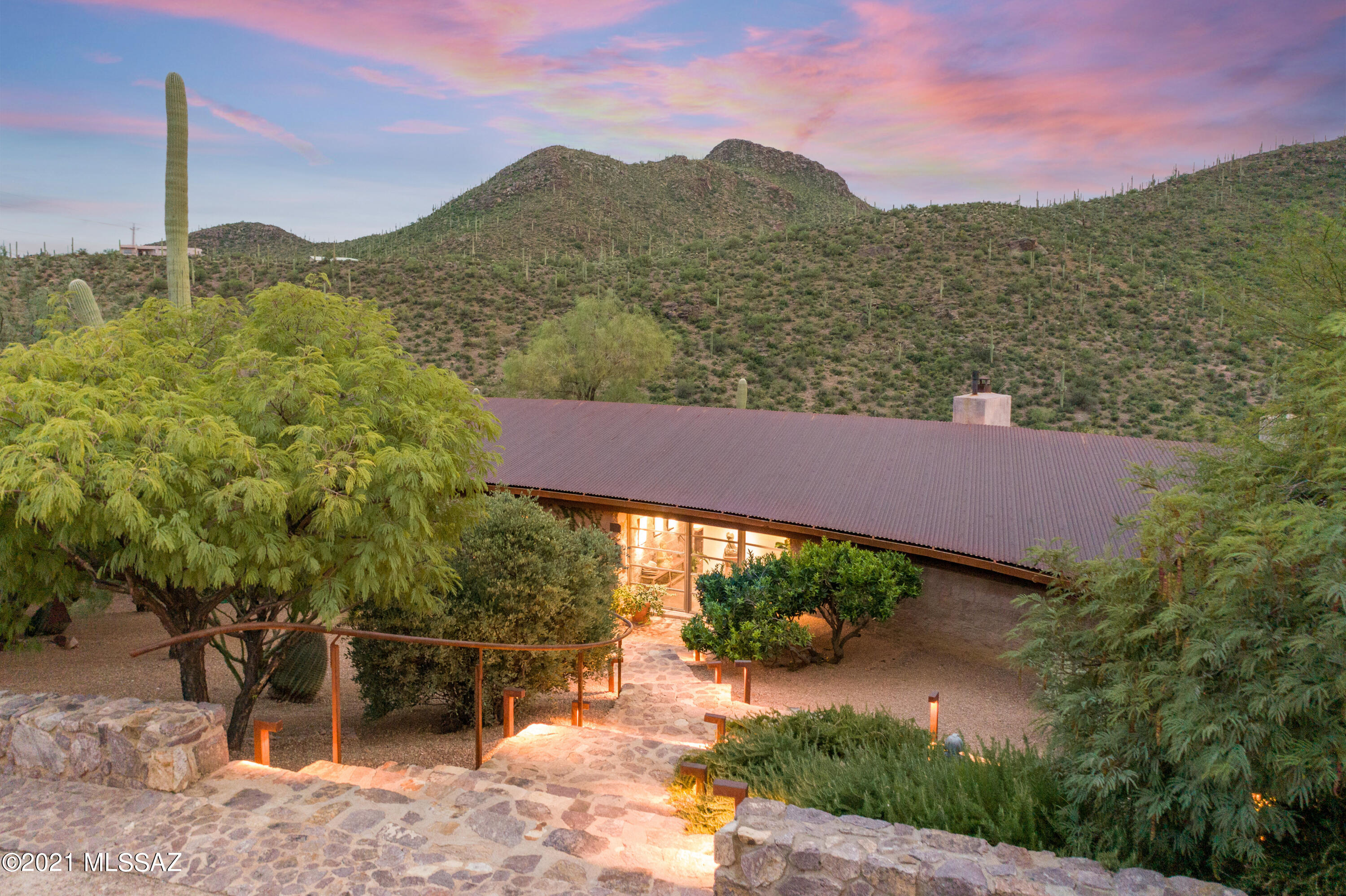 Awarded Home Of the Year by Metropolitan Home Magazine, January 2000, the sanctuary at the end of Chaos brings privacy and seclusion to a lush green box canyon 15 minutes from downtown Tucson and the U of A. This uniquely designed home by award-winning architect Rob Paulus built with a sophisticated palate of organic materials provides a calming, centering experience at the edge of the wilderness of Saguaro Monument West and Tucson Mountain Park.  Equal attention has been given to the indoor/outdoor living experience including 36 clerestory windows spanning the length of the house from east to west delivering passive solar heat in colder months and extraordinary light to the middle of the home year round.  40 mature trees provide shade, dappled light and lush privacy.