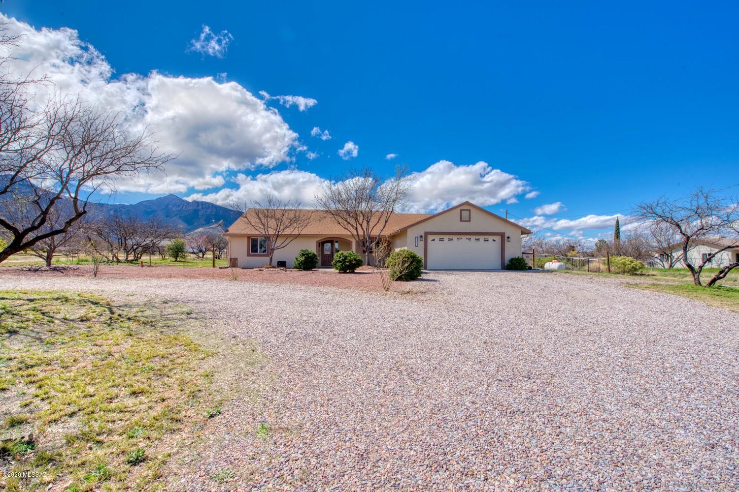 BEAUTIFUL custom home with 1.18 acre on a paved road! Close to town but has a country feel. 4 bedroom, 2 bath, with 2 car garage. Open concept with HUGE kitchen and living space.  Stainless kitchen appliances installed in 2017. Tile throughout–no carpet. Gas fireplace AND wood burning stove. Exterior paint, bedroom tile, and gutters installed in 2018.  Need space to park an RV? This home has an RV gate and covered RV parking. Enjoy amazing mountain views from your extra-large covered back patio. A gardener's dream–fully fenced backyard with mature apple, peach, Asian pear, and pomegranate trees, huge fenced garden area with raised beds and a 600-gallon rainwater harvester. Children's jungle gym can convey along with a Conex box for extra storage. This property won't last long! Call tod