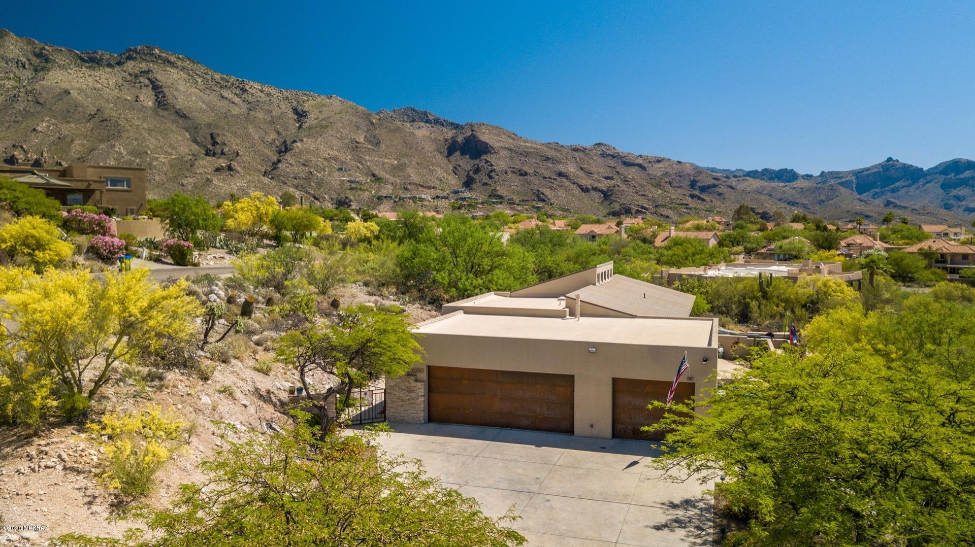 STUNNING VIEWS!! Impeccably maintained CATALINA FOOTHILLS HOME is located in the HIGHLY ACCLAIMED ALTA VISTA, surrounded by CATALINA MOUNTAIN VIEWS AND TUCSON CITY VIEWS, making this a VISUAL DELIGHT! Home sits on almost an acre of land and tucked away at the end of a quiet CULDESAC. You will fall in love while walking through all the bright and airy spaces from room to room. The living area is the perfect entertainment space, adjacent to the kitchen and dining area. STAINLESS STEEL appliances and gas range are surrounded by WHITE KRAFT MAID CABINETS that come with a LIFETIME WARRANTY REPLACEMENT! The split floor plan features TWO CHARMING GUESTROOMS  and STUNNING BATHROOM on one side of the home. The large LAUNDRY ROOM with plenty of counter space and sink will make doing laundry a pleasure instead of a chore. Don't forget to check out the 3 CAR GARAGE. Two car garage has BUILT IN STORAGE SHELVES. Third car garage is totally walled and separated with its own entry doors. Did I mention it is insulated and has a/c, making the perfect OFFICE SPACE or WORKSHOP!! On the other side of the home is the MASTER SUITE offering a LARGE WALK IN CLOSET with smartly designed, CUSTOM BUILT IN SHELVES, ELEGANTLY UPDATED BATHROOM with DOUBLE SINKS, TONS OF COUNTER SPACE and DRAWERS, LARGE SHOWER and GARDEN TUB. Don't miss the OFFICE/DEN before heading out to the resort like backyard. You'll be enchanted by the views and all this amazing yard has to offer. Imagine all the fun times you'll have in the NEGATIVE EDGE POOL, the LARGE SPA, all the evenings enjoying the CITY LIGHTS by the GAS FIRE PIT, relaxing and loving your very own piece of PARADISE! You couldn't ask for a better place! This is a HOT PROPERTY and WON'T LAST LONG! MAKE IT YOURS TODAY!