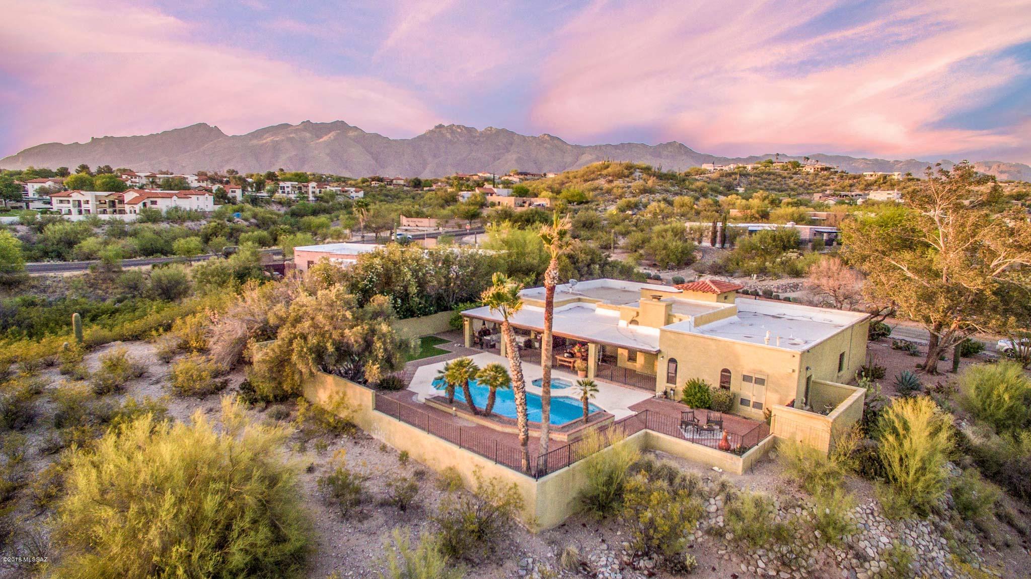 Majestic sunsets and Tucson city views abound on updated 2,688 Sq Ft three bed/two full bath +flex room, masonry stucco Southwestern desert jewel on .88 acre in desirable North Tucson. Features/updates: Mountain & sweeping city views, solid wood doors & trim throughout, double pane windows, copper plumbing, roof recoated 2016, custom plantation shutters, updated LED lighting & fixtures, skylights, modern ceiling fans, high wood plank ceiling, fresh no-VOC paint inside, hand scraped Acacia wood flooring, marble tile, gas fireplace in living room, Spanish tile beehive wood burning fireplace family room, formal dining room w/Mt views, central vac, internal laundry room w/cabinet storage, energy efficient zoned AC, 2X water heaters, digital thermostats, alarm w/5 camera surveillance CONT system, Nest smoke & CO detectors, spacious master bedroom w/ slider out to heated pool/spa, large walk in closet and attached private study/den/nursery/workout or "flex" room, finished attached two car garage plus storage. Modern kitchen w/stainless steel appliances, skylight w/retractable blinds, full slab granite counters, ample updated cupboards w/pullouts and serving bar. An entertainers dream, enjoy tranquil private backyard under massive covered patio w/saltillo tile surrounded by masonry stucco wall, artificial grass, cool decking, Spanish tile heated pool/spa recently replastered, recently added sand filter, pool equipment and heater, pool autofill, with low maintenance, mature native vegetation, fruit trees and new drip irrigation. Convenient location to Rillito Loop and walk to esteemed BASIS charter school, River Center neighborhood shopping w/Whole Foods, Walgreens, PetCo. Restaurants: Harvest, Caffe Torino, Yukari Sushi, Island Plate, Jimmy's Pizzeria, Subway, E.River Road Bar. Health/Beauty: Orange Theory Fitness, Animas Pilates, Arias Dentist, Rejuvination Spa, Star Nails, Mila's Hair Salon, US Cryotherapy. Family Services: Pima County Library, River Road Pet Clinic, Childtime Childcare, State Farm Insurance, Comcast, Sparkle Cleaners, Living Space Design. Call to make your appointment to view today.