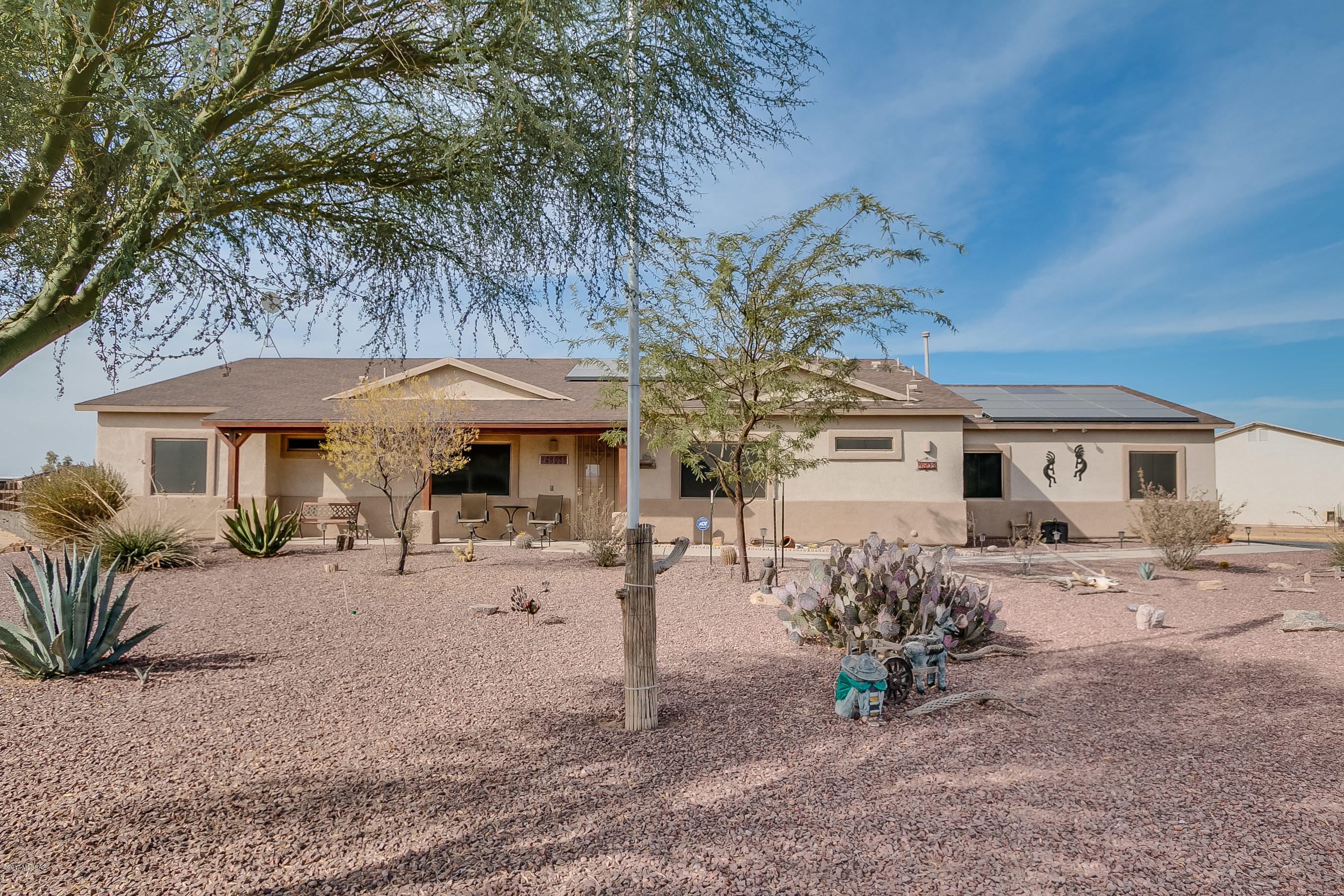 Wonderful contemporary ranch-style model home on spacious corner lot, .91 of an acre. Great curb appeal, recently painted & well maintained. Graveled yards, desert plants & substantial porch-cover patios front & back. Backyard is secure & snake proof. There is a fire pit area on outer West side of lot, also good for RV access & storage. The interior recently painted through-out, with open generous living area. The kitchen upgrades include beautiful cabinets, tiled floor & granite counters with quartz double sink. The master is roomy w/a garden tub & separate shower. The split bdrm plan design is great for guests & for easy adaption to an office room. The 3 car garage has ample work/storage space, the double garage door has a back-up power supply & 2 wood work-benches/peg boards to convey. A must see home!