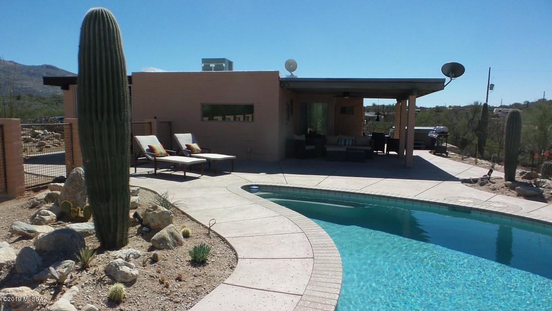 Great Vacation Rental with many repeat customers. Property has the privacy and views every vacation renter is looking for when they travel to the southwest. Private pool and hot tub surrounded by the desert with plenty of big views of the Catalina and Rincon Mountains. House was updated in 2016 and square footage included non-permitted garage conversion.  Furnishings available on separate bill of sale-not included in asking price.  Room to add an additional dwelling. Members of LLC are licensed real estate agents in State of Arizona