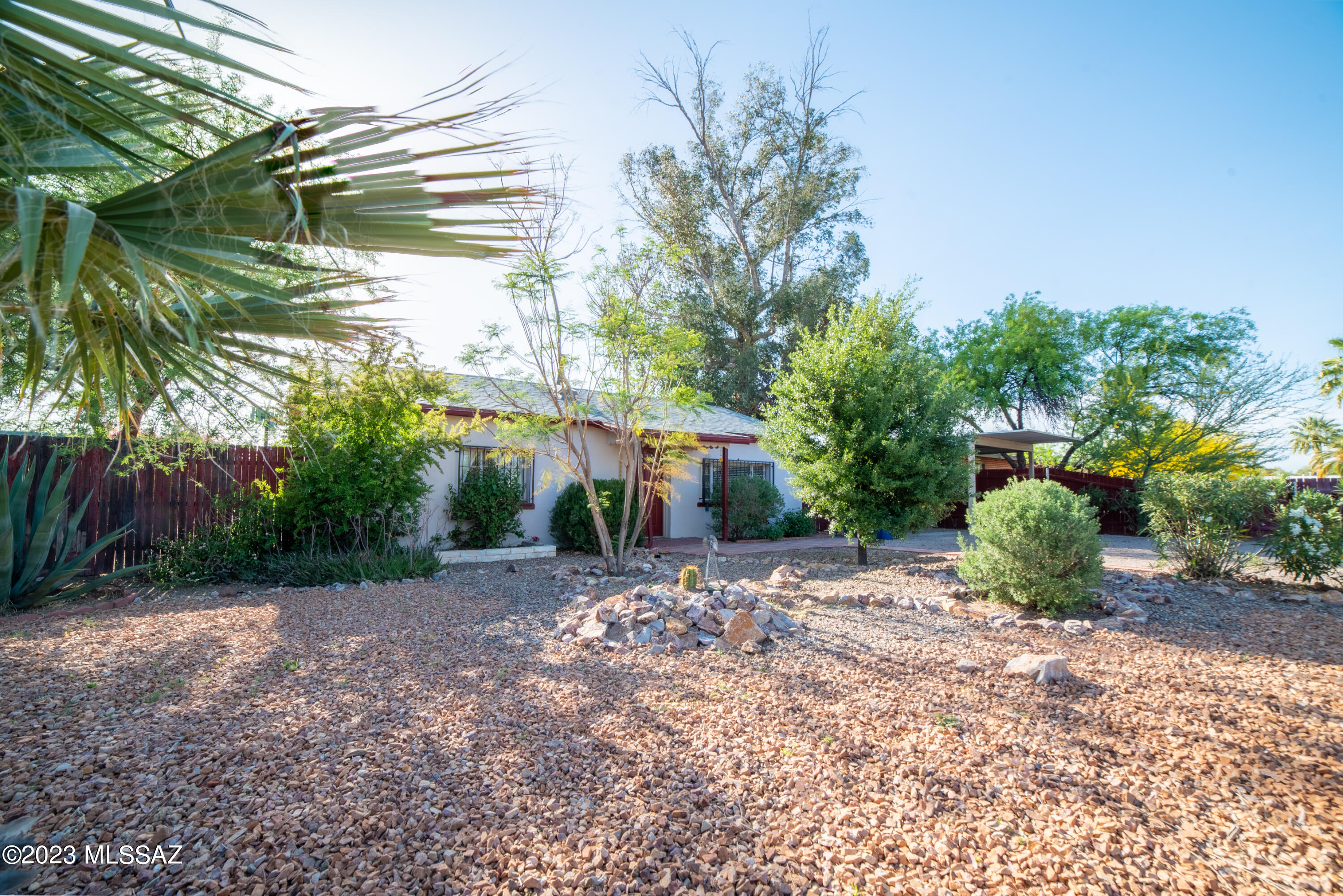 Classic mid-century, mud adobe home. This centrally located 2 bed, 1 bath home sits on a nearly quarter acre lot. Nestled in a quiet neighborhood, close to the UofA, tons of shopping, and the Rillito bike path. Kitchen has been remodeled with new cabinets, counters, and appliances installed in 2018. New flooring in the living room, bathroom, and primary bedroom. Bathroom updated in 2018. Ceiling fans in every room. Lush landscaping in both front and back yards. Huge backyard  has a covered patio, a free-standing gazebo, mature pomegranate and eucalyptus trees, and a new (2020) large shed with lights and power. Brand new roof and gutters installed in 2022. Entire house replumbed to PEX in 2018. Sellers have an assumable VA loan and are open to a loan assumption by a qualified VA buyer.