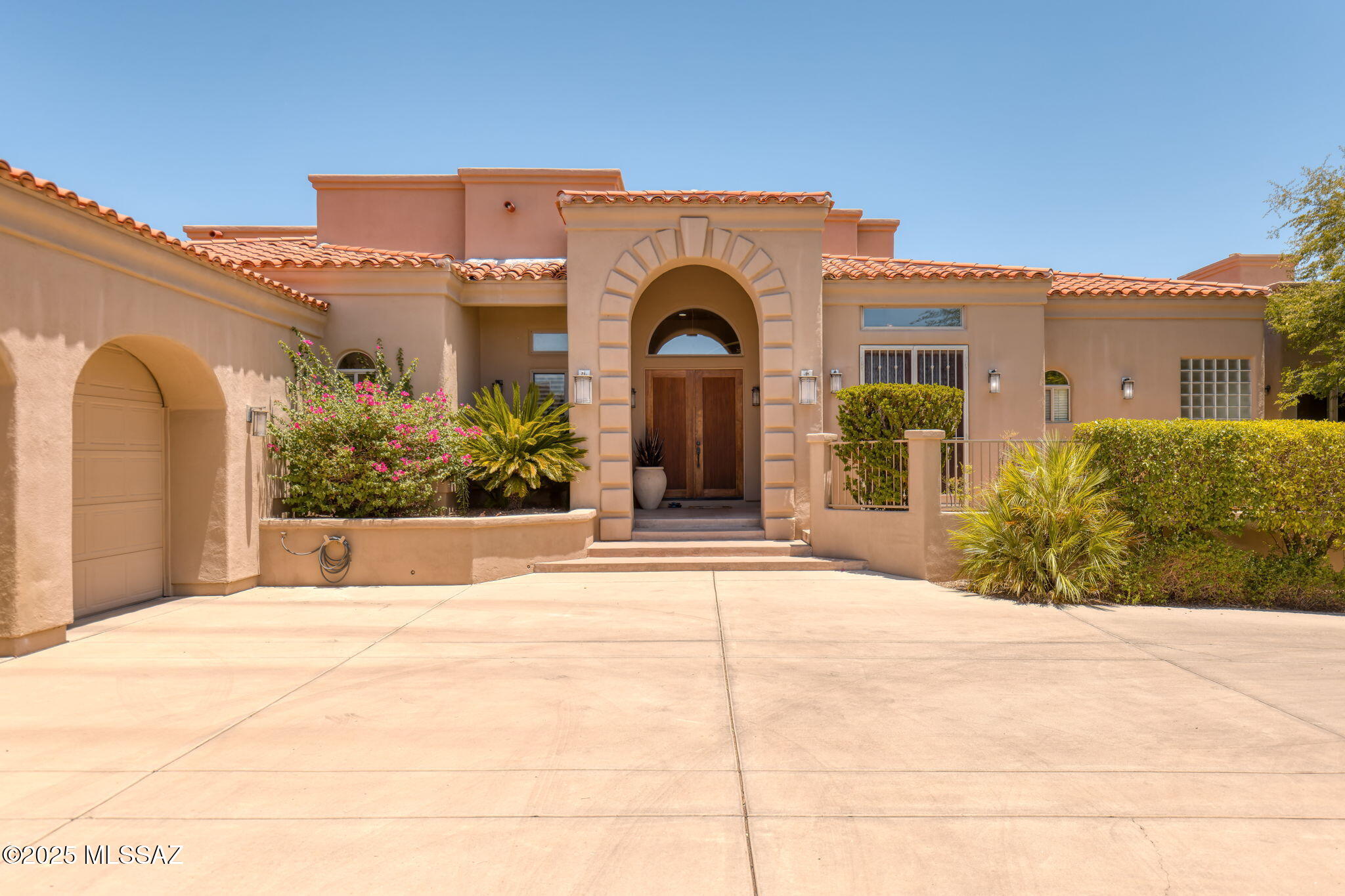 Located within the exclusive, guard-gated Canada Hills Estates, this custom residence offers a refined living experience amidst the natural beauty of Oro Valley. Designed to highlight breathtaking mountain views from the elevated location, the home features expansive windows in key areas, bringing natural light into the main living spaces. The spacious primary suite is situated in its own wing, creating a private and comfortable retreat. This suite includes a sitting area, 3 way fireplace, reading nook, large walk-in closet, extensive storage, separate vanities, a generous walk-in shower, private access to separate patio and out to backyard. The guest rooms offer access to private bathrooms, ensuring comfort for visitors. Additionally, a dedicated office features its own exterior entrance, ideal for privacy and convenience and there is a separate media room complete with a fireplace and backyard access, perfect for a game room or fun movie nights.. The well-appointed kitchen features premium finishes and ample storage, suitable for both daily use and entertaining. Travertine flooring, high ceilings, and a three-car garage complete the interior. Outside, there is no reason to even leave the property as it provides a private setting designed for recreation and relaxation! The custom pool is ideal for laps, and includes a diving board and a slide for added fun. The versatile sport court is ready for tennis, pickleball, and basketball, offering numerous options for outdoor activity. Should you wish to venture out into the community, this property provides easy and quick access to an active Oro Valley lifestyle. The surrounding area features multiple parks with a variety of amenities, including archery, dedicated dog parks, walking paths, splash pads, sports fields, a skate park, a BMX park, pickleball courts, a mini air flyer park and a Veterans Memorial Park. Nearby, the local recreation center offers golf, fitness facilities, additional pools, and tennis courts. While most recreation center amenities require membership, the on-site restaurant is open to the public. This home offers a comfortable lifestyle with a range of amenities readily available. We invite you to experience this offering through our dedicated lifestyle video.