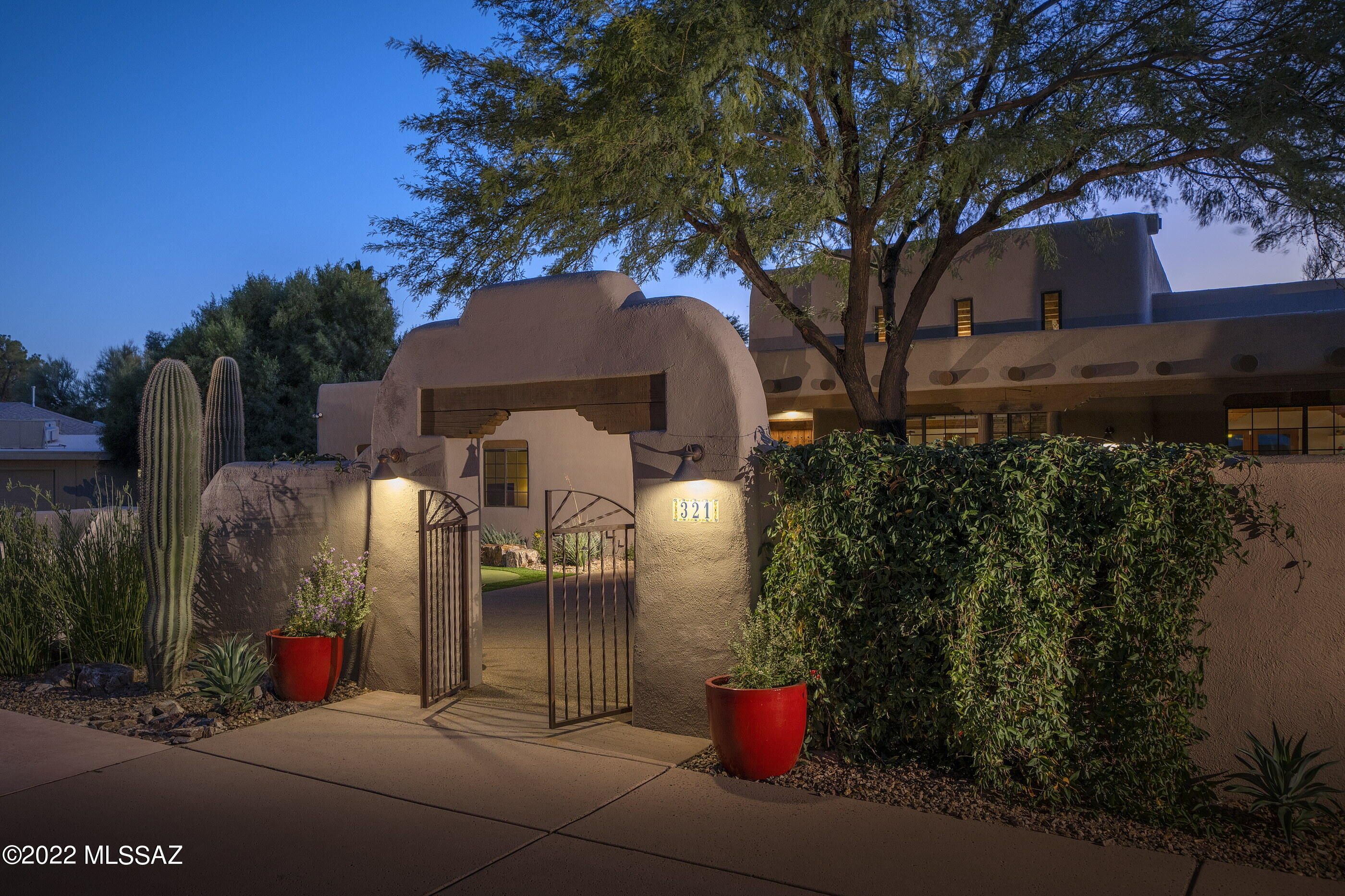 Rare Southwest-style property located in the sought-after Oro Valley Country Club is loaded with character! 4 bedrooms, 2 baths, 2694 square foot home is finished to the hilt—latilla ceilings, polished concrete floors, 3 fireplaces (including double-sided floor to ceiling fireplace in the living space), clerestory windows and more. Beautifully outfitted kitchen offers a beehive fireplace, rich cabinetry, creamy quartz counters and all appliances including gas range. Primary bedroom suite with beamed ceilings and fireplace also has a private courtyard and upscale bath. All bedrooms have new carpeting. Outdoor spaces feature sunset, mountain and golf course views from the back, and mountain views from the front courtyard. Staycation ready with a pool/spa/putting green. TRULY A MUST-SEE!!