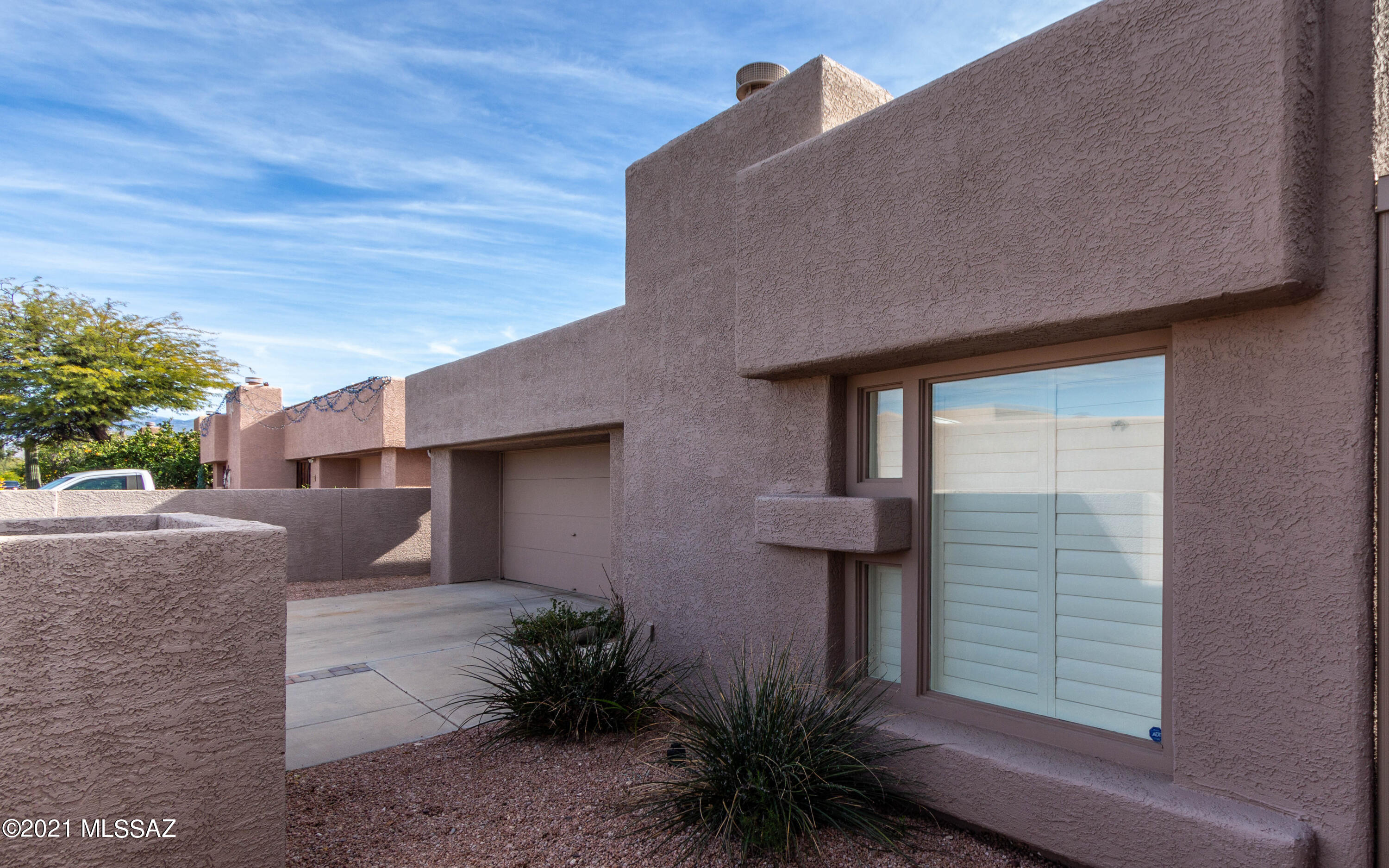 Fantastic home designed by David Tyson in Broadway Court, a small enclave of contemporary homes on the east side of Tucson. Tons of upgrades have been recently done including a top-of-the-line Lennox HVAC, quartz countertops and full height backsplash installed in the kitchen, high grade carpet, new shutters, new gutters, newer appliances (including the refrigerator, washer, and dryer), and so much more. This home is made for entertaining with a spacious great room and open kitchen along with a separate family room with a cozy gas fireplace. One of the 4 bedrooms has a wall of built-in shelving and would make a great work from home space. The neighborhood has a gate to allow access to a path that leads to Case Natural Resource Park.