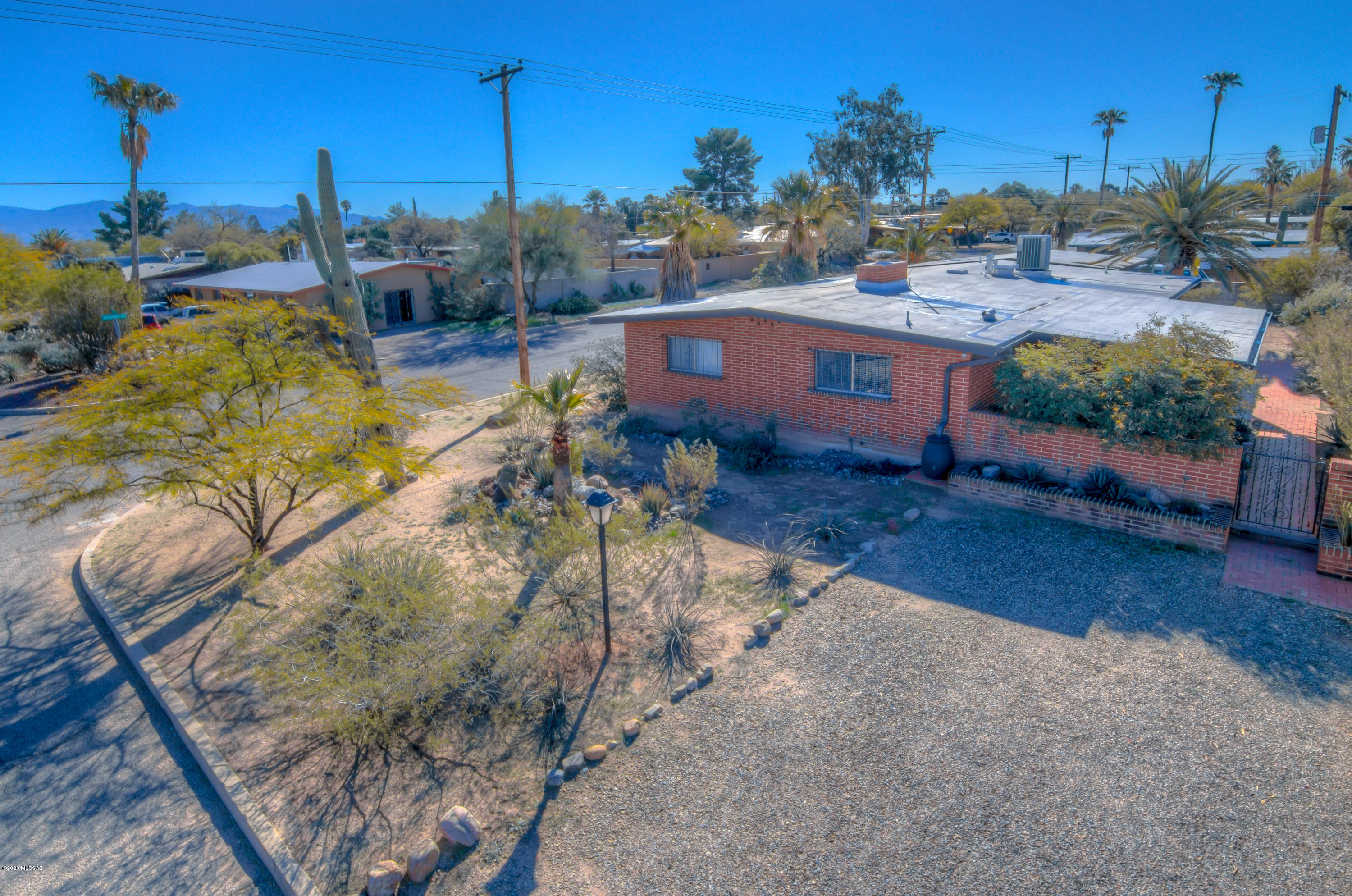 CHARMING AND IMMACULATE! Centrally located with tons of character, this spacious, inviting mid-century home is on a corner lot in quiet, established Mitman neighborhood - Walk to Trader Joe's, Beyond Bread, Bookman's! Lovingly updated throughout including huge, open kitchen with tons of cabinets, breakfast bar seating, dining area and fireplace. Formal dining room is office/game room now, but could be converted to 4th bedroom. Updated bathrooms, flooring & window coverings (plantation shutters.) Newer HVAC, water heater and recently resealed/coated roof. Lots of windows to let in light! Private side entrance w/ covered patio, low-care/mature landscaping and rainwater harvesting. 2-car garage, laundry room with lots of storage. Roomy, bright and ready for you to move in - WELCOME HOME!