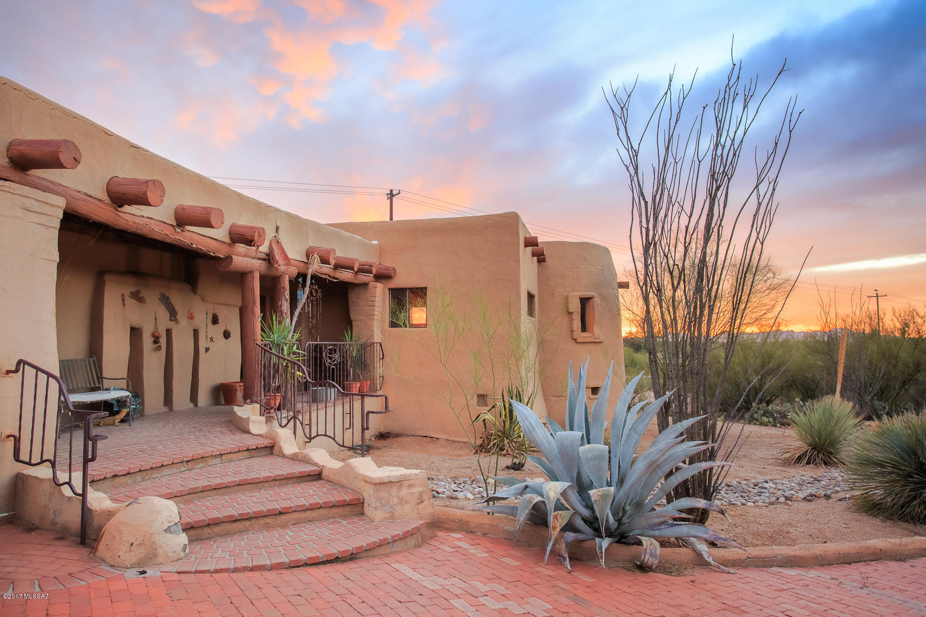 WONDERFULLY UNIQUE AND ARTISTIC SANTA FE STYLE 3 BEDROOM, 2 BATH HOME WITH A GUEST HOUSE/FIREPLACE/LOFT/DECK, RAMADA, STUDIO/SHOP/REC ROOM AND 4 CARPORTS WITH AVAILABILITY TO ACCOMMODATE 7 CARS LOCATED ON THE NEAR NORTHEAST SIDE IN A GATED COMMUNITY. HANDMADE COPPER DOORS WITH LEVER HANDLES THROUGHOUT, BENCH SEATS, ALCOVES, INTIMATE ENCLOSURES, RECESSED NICHES, MULTI INTERIOR ELEVATIONS, BEAMED CEILINGS AND MUCH MORE.  DON'T MISS THIS OPPORTUNITY TO ACQUIRE THIS RESIDENTIAL GEM WHICH WILL REQUIRE YOUR HANDY TOUCH TO MAKE A RARE LANDMARK.  SOLD IN AS-IS CONDITION.
