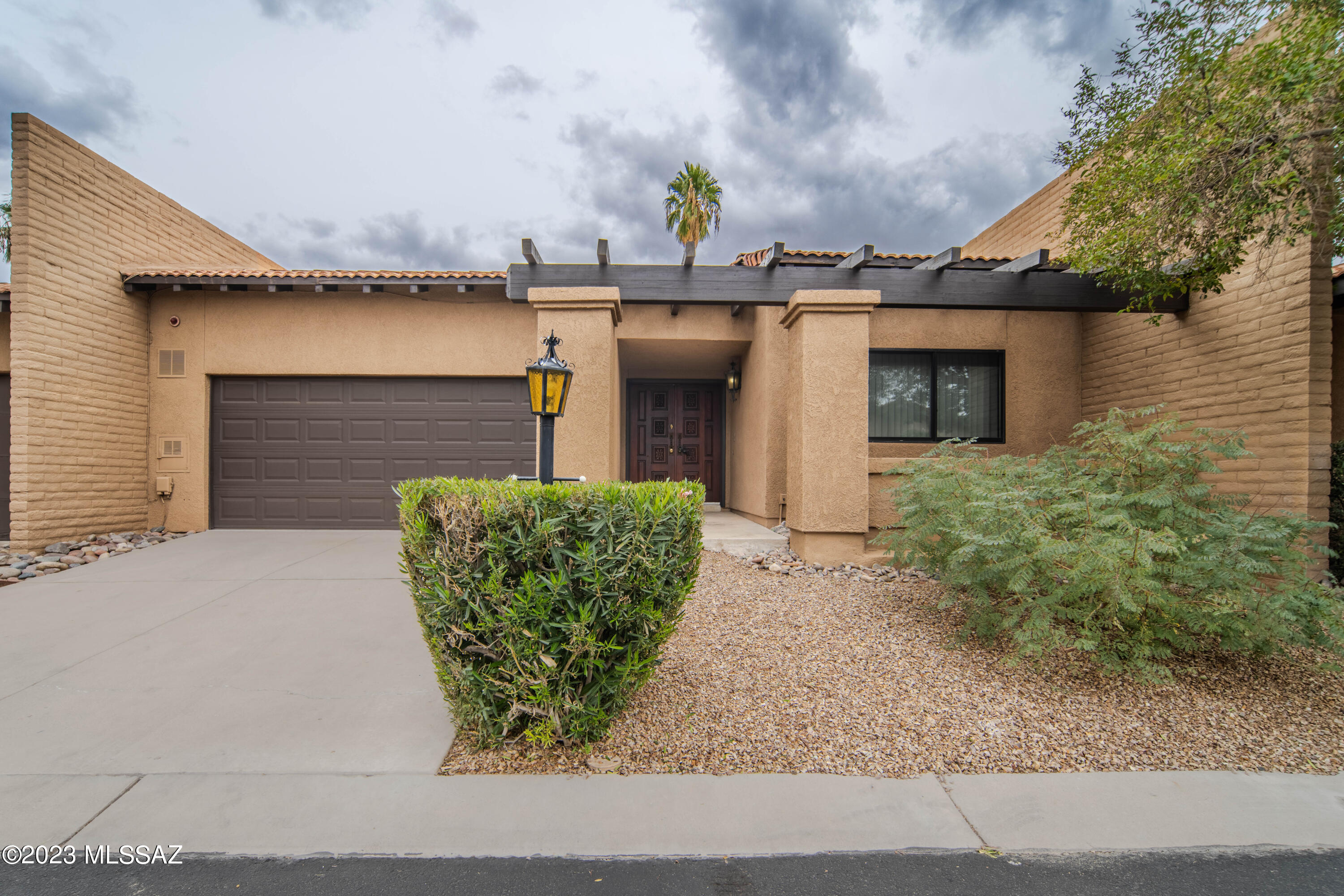 Rare opportunity - make this lovely townhome your own in the heart of central Tucson in a highly desirable community. Beautifully maintained and improved by the sellers during their ownership, 2 bedrooms and 2 full baths are thoughtfully arranged in this great split floor plan. A large dining room and family room are great for entertaining, plus an impressive stone fireplace is perfect to cozy up to this time of year. Amazing natural light throughout thanks to huge windows and private atriums, ceramic tile and carpet, a remodeled kitchen with appliances included. Anderson windows and sliders, granite counters, and a new roof are just a few of the features. A spacious two car garage and a low-care private backyard are the cherry on top. Come see it today - it won't last long!